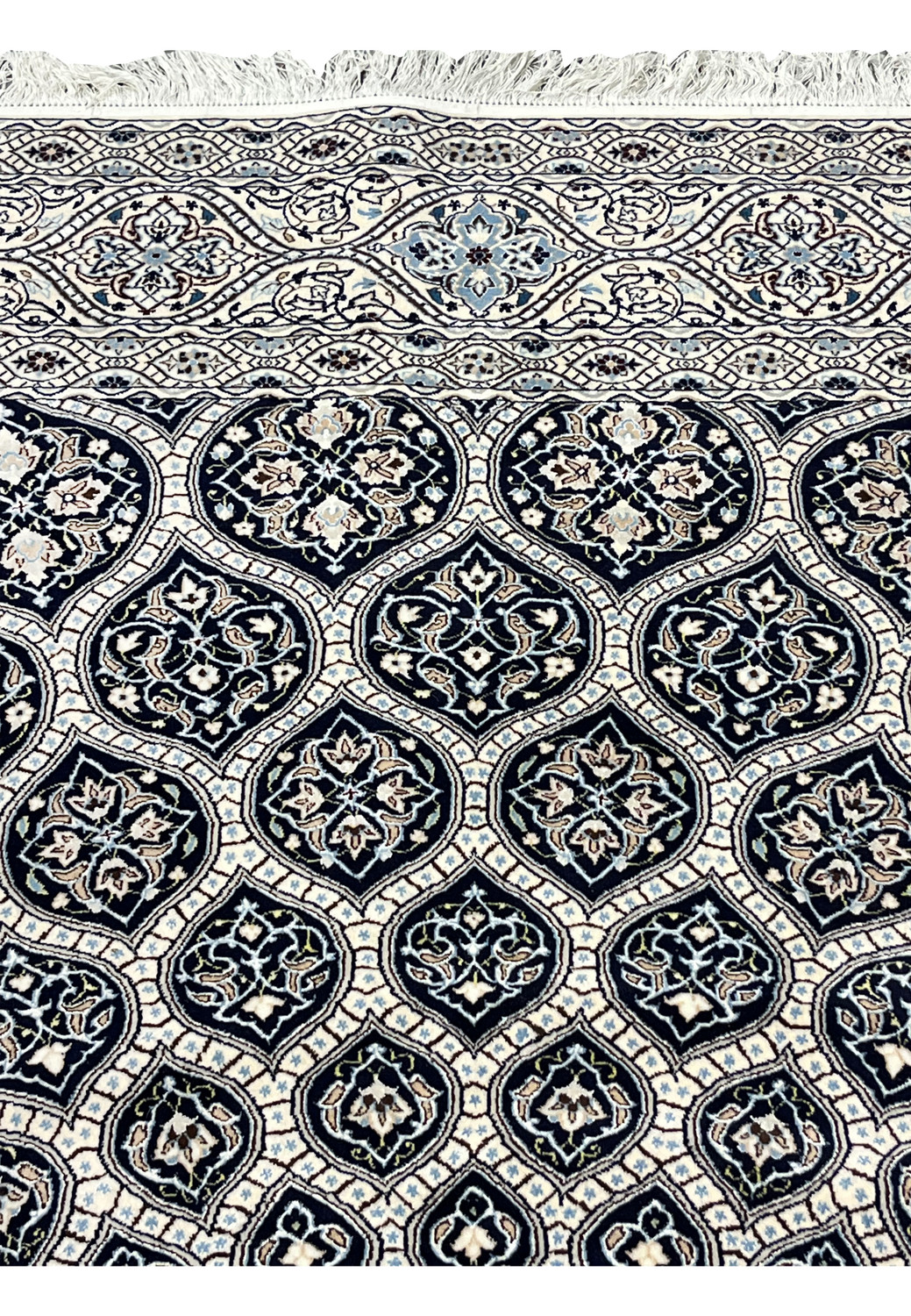 Floral and vine motifs on Persian Nain 6 LA rug with ivory background navy panels and soft blue accents.