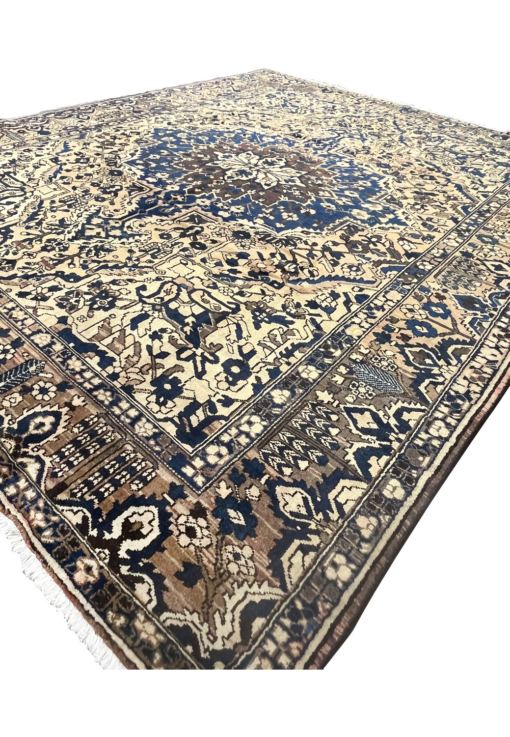 Low angle view of large geometric Persian Heriz rug in muted navy blue and ivory with classic tribal border pattern