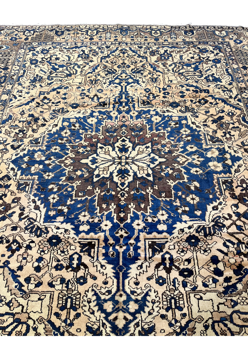 Detailed center medallion of vintage Heriz rug in muted navy blue and ivory wool with bold geometric floral design