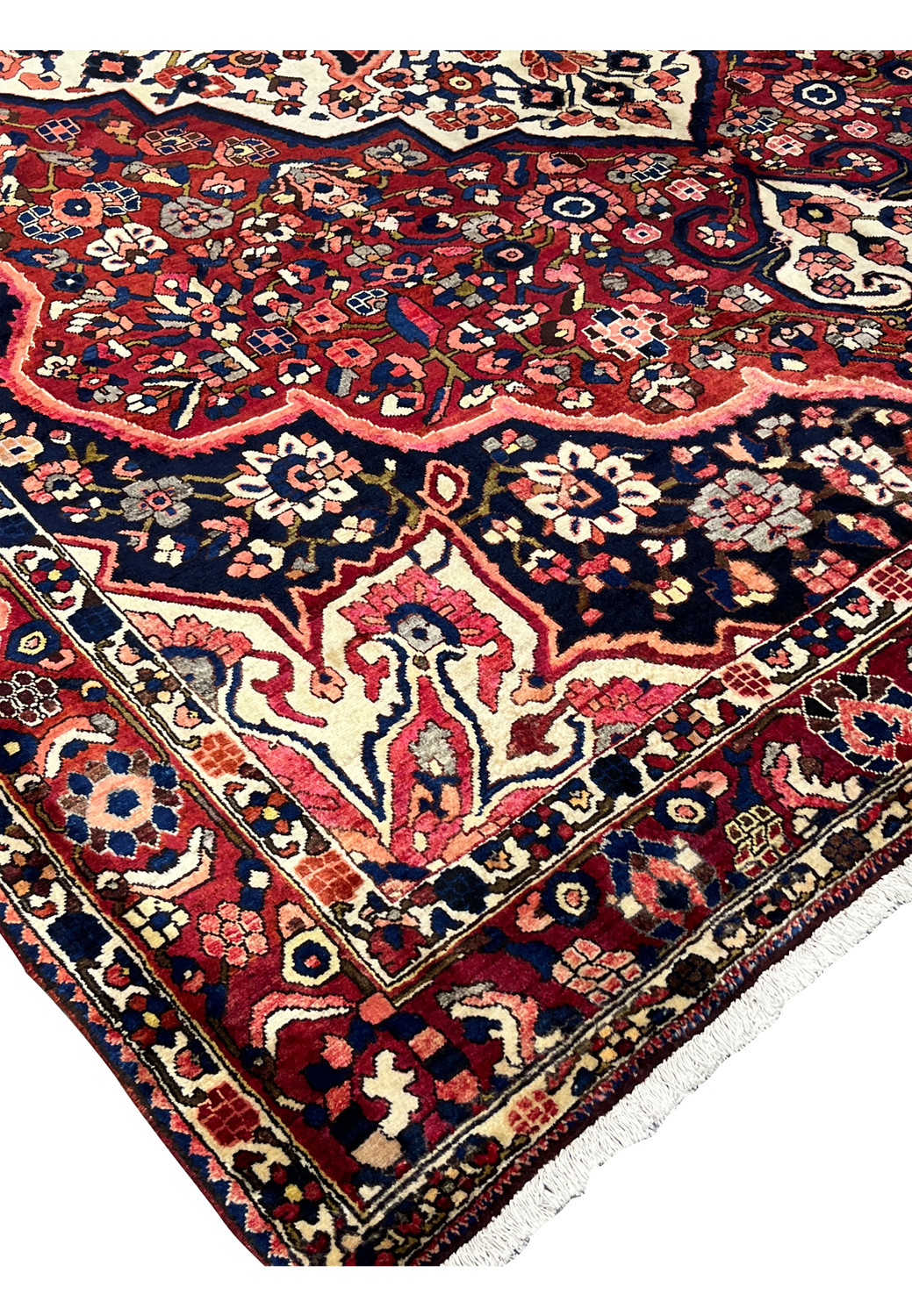 Corner detail of vintage Persian Bakhtiari rug showing hand-knotted wool pile and floral spandrel motif.