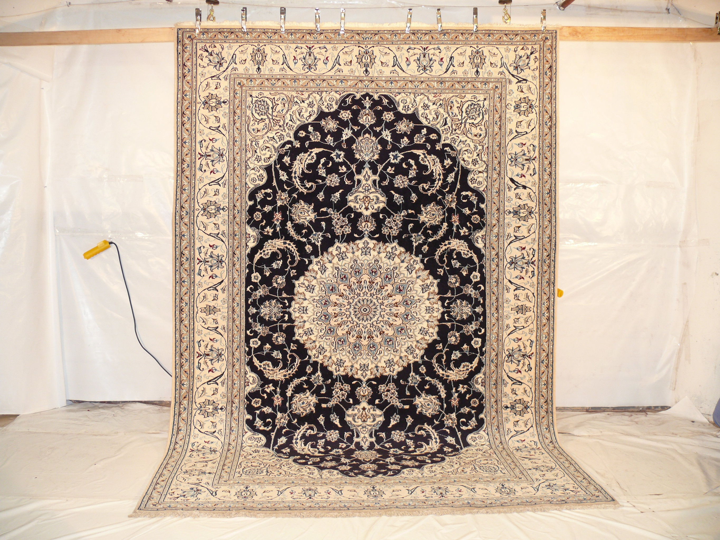 9x12 Nain Persian Rug hanging and showing its perfect wool and silk design