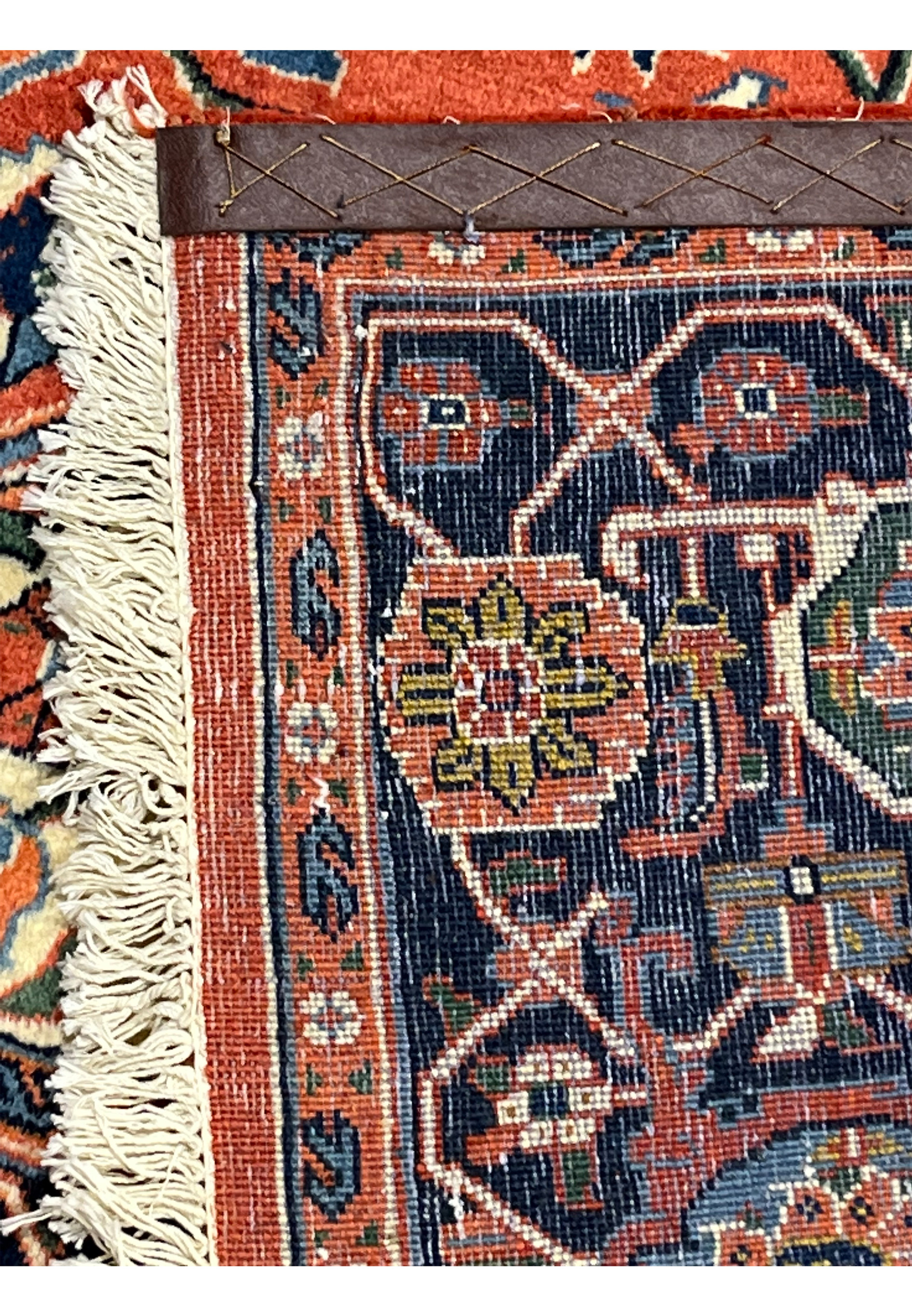 Backside of a hand knotted Persian Heriz rug showing tight knot structure, cotton foundation, geometric border pattern, and visible craftsmanship