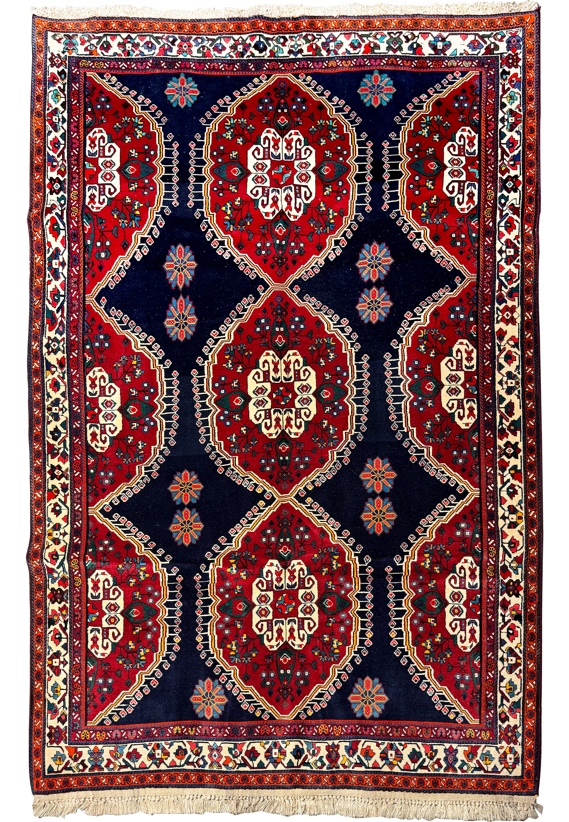 Full view of a traditional Qashqai rug displaying symmetric patterns and multiple borders, with dominant red and dark blue colors, and white fringes on the ends