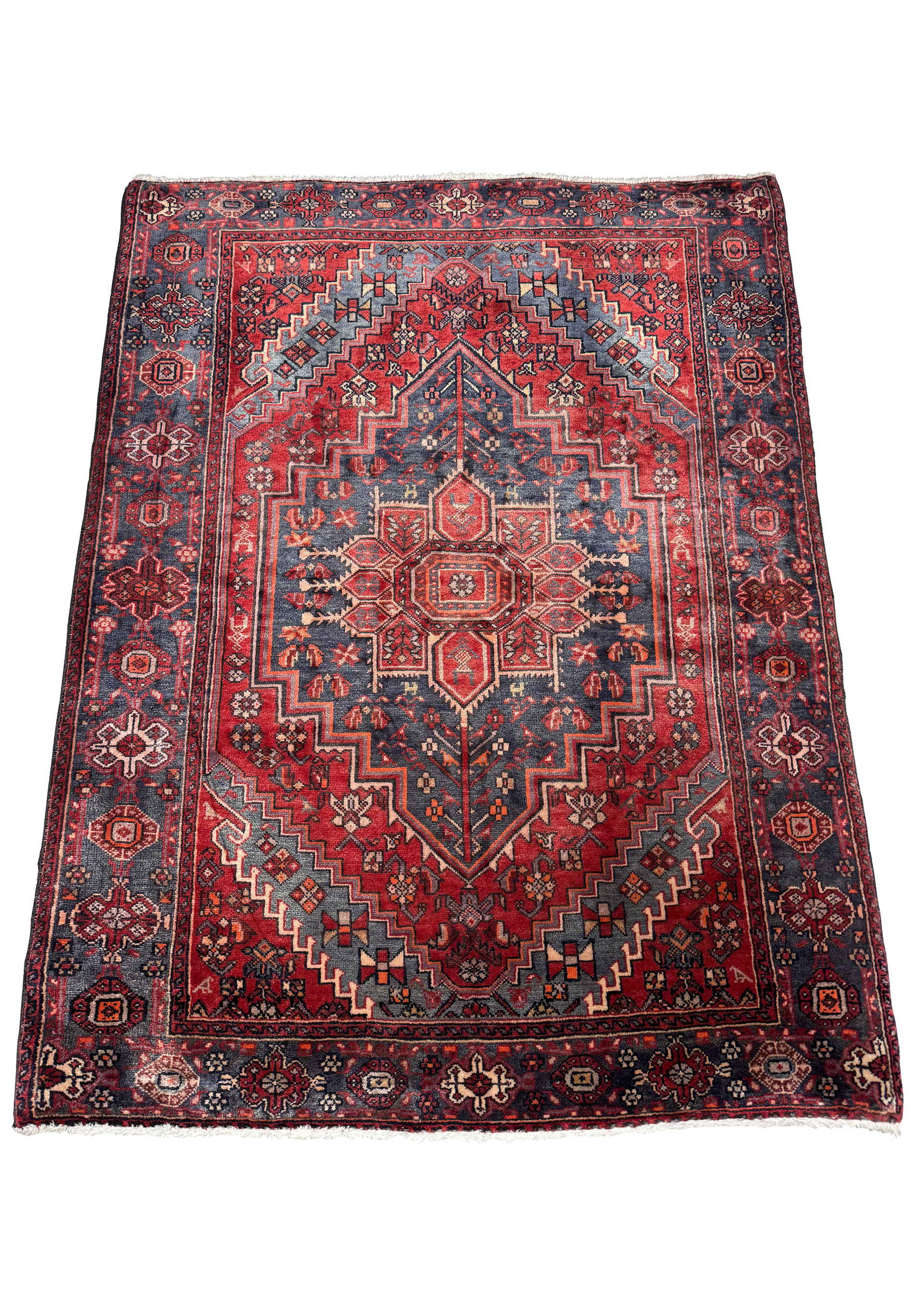 Entire vintage Persian Bijar rug displayed on a flat surface, highlighting its elaborate geometric patterns and the traditional red and blue colors