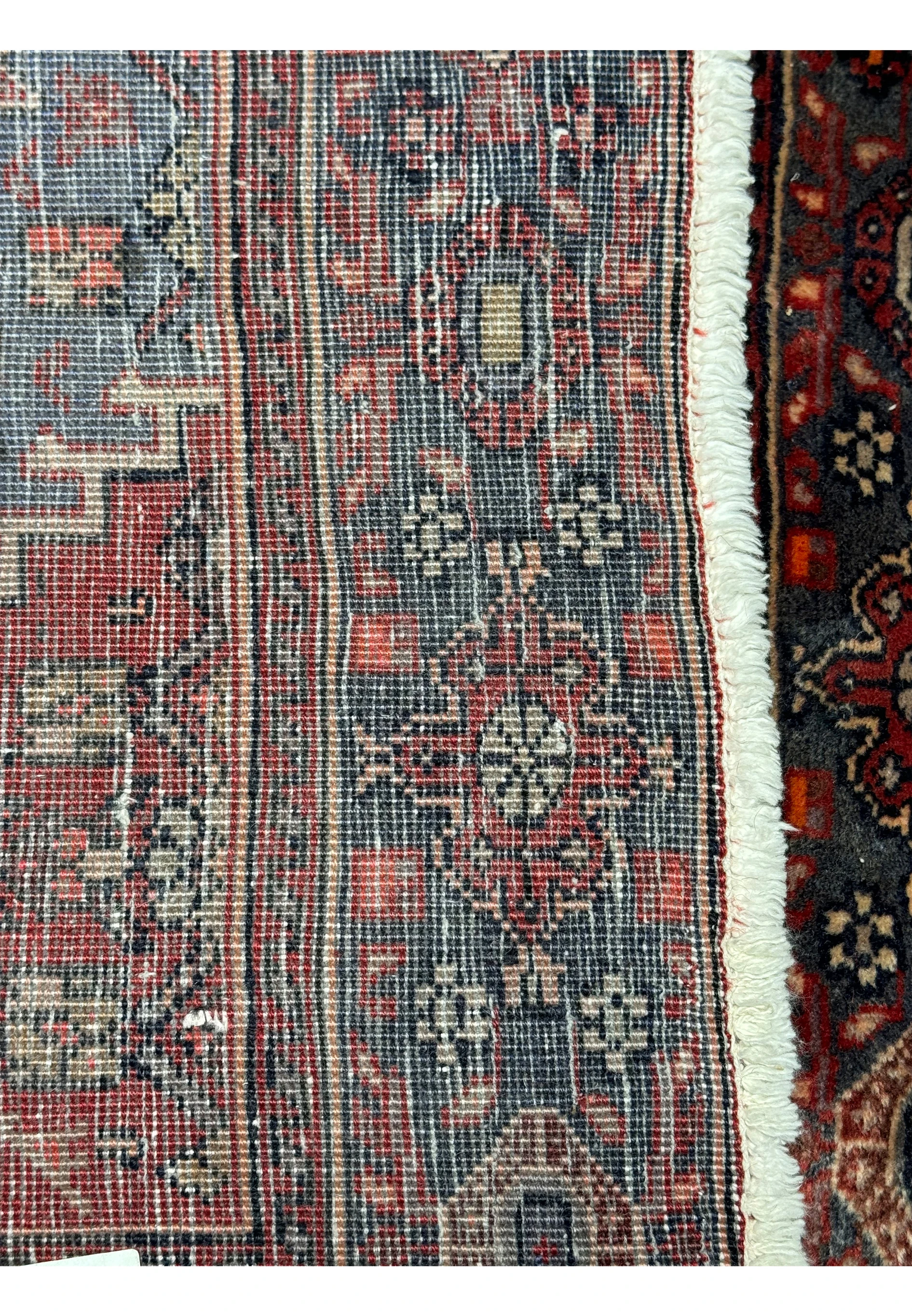 Detail shot of the fringe and back weave structure of a vintage 4x5 Persian Bijar rug, displaying the craftsmanship and the red and blue color palette