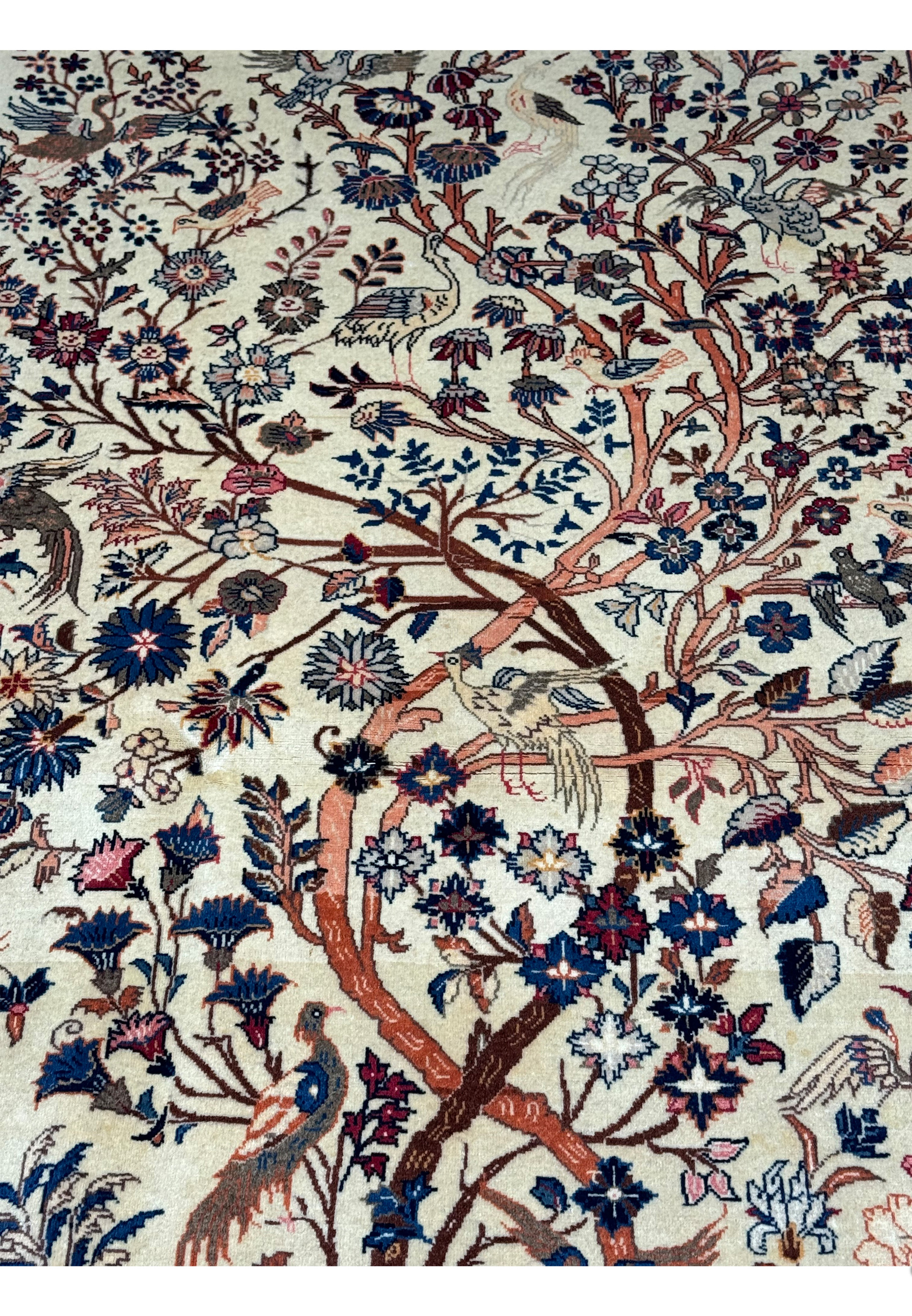 Close-up view of the upper part of a 4'2" x 6'9" Antique Persian Kashan rug, emphasizing the Tree of Life's branches and surrounding animal figures in vibrant hues