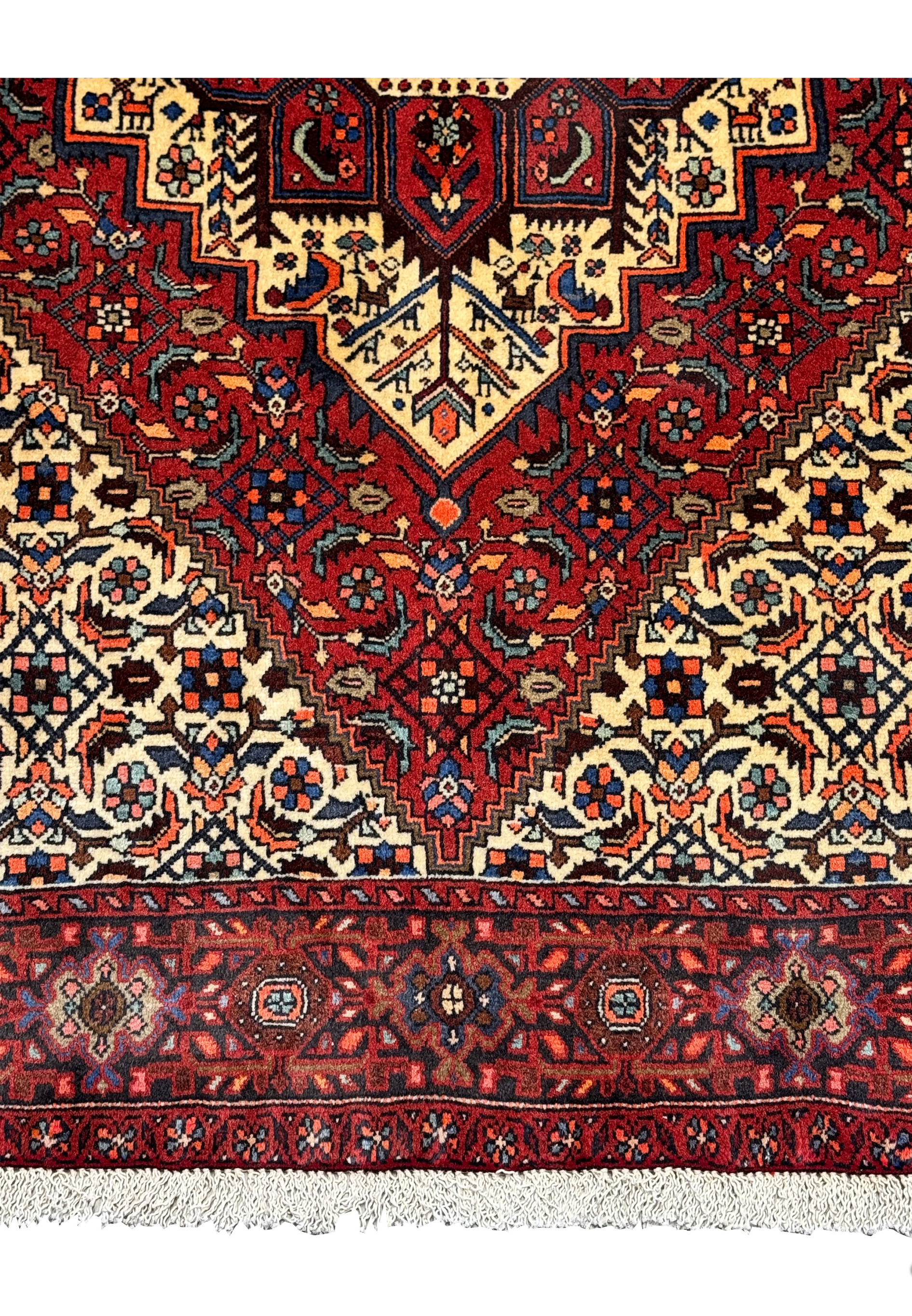 Close-up of the Persian Gholtogh rug's detailed geometric motifs and deep red background