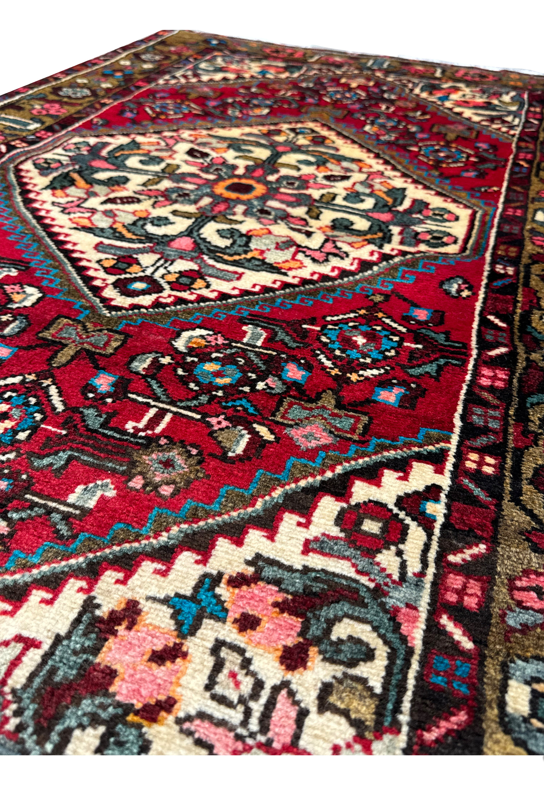 Angled view of the Persian Hamedan rug displaying the plush pile and ornate designs