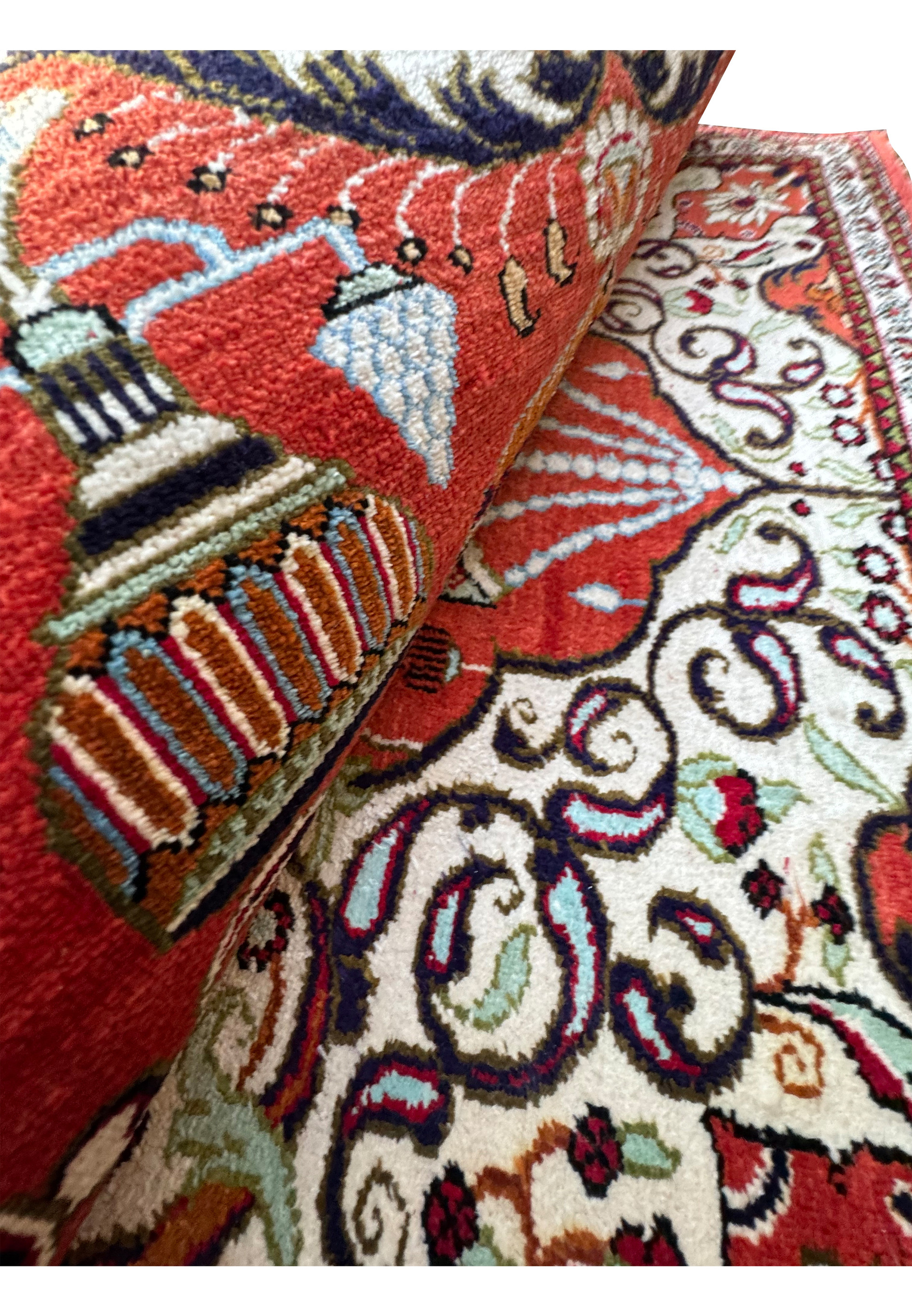 Folded Persian Qum silk rug showing the luxurious sheen and rich color palette