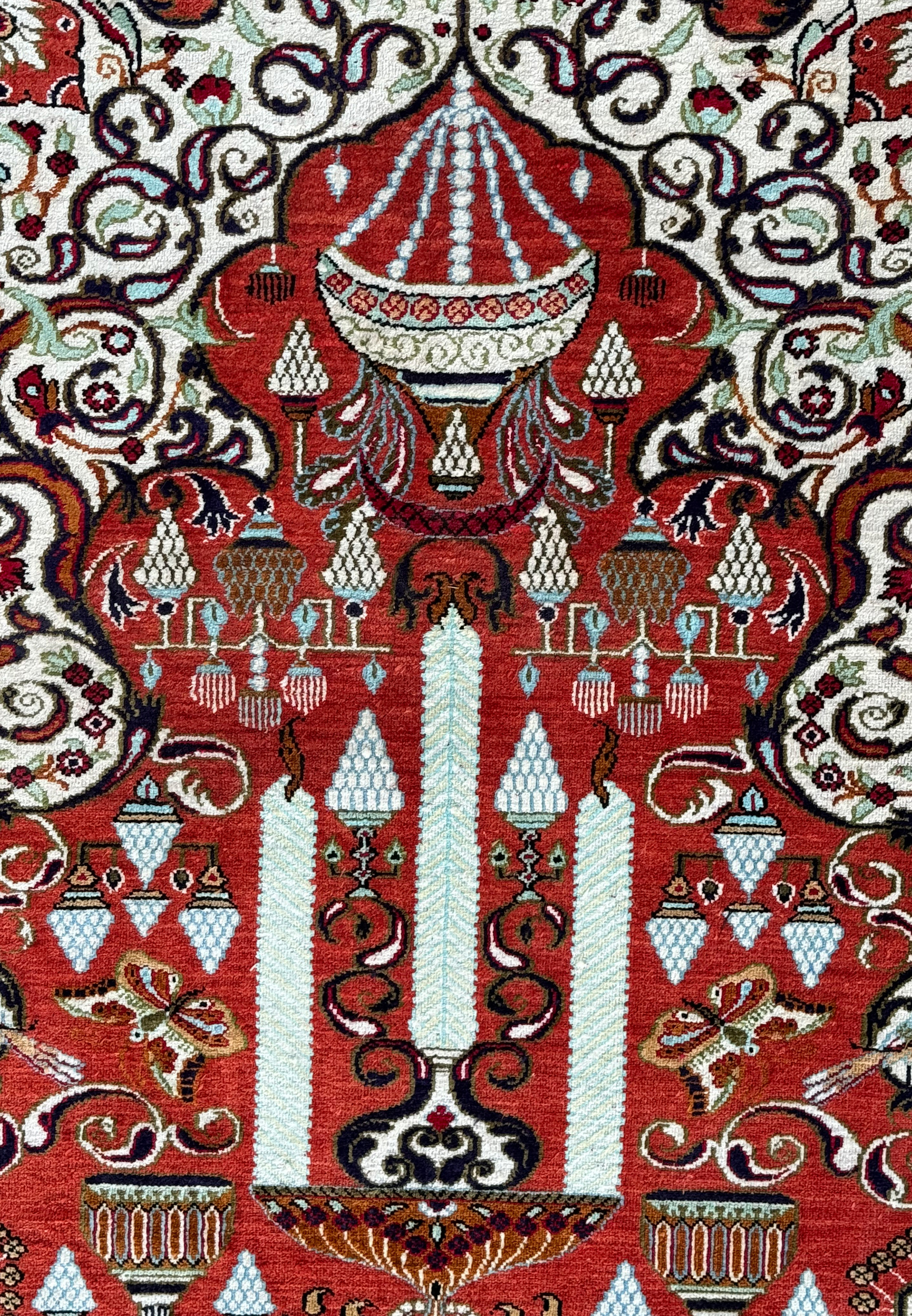Close-up of a Persian Qum silk rug showcasing intricate patterns including cypress trees and florals