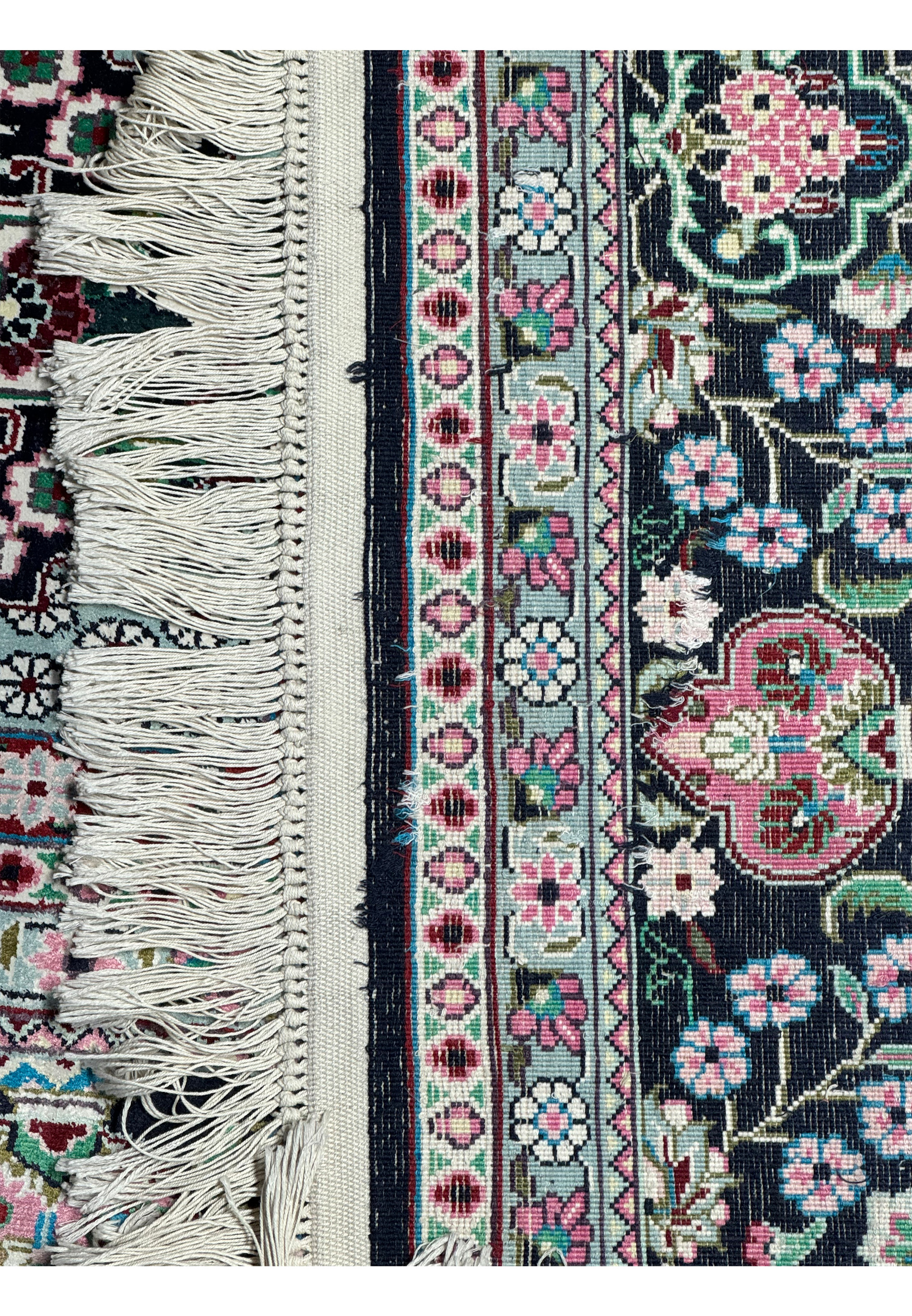 Detail of the fringe and weave structure of a Persian Qum silk rug, displaying exceptional artisanship