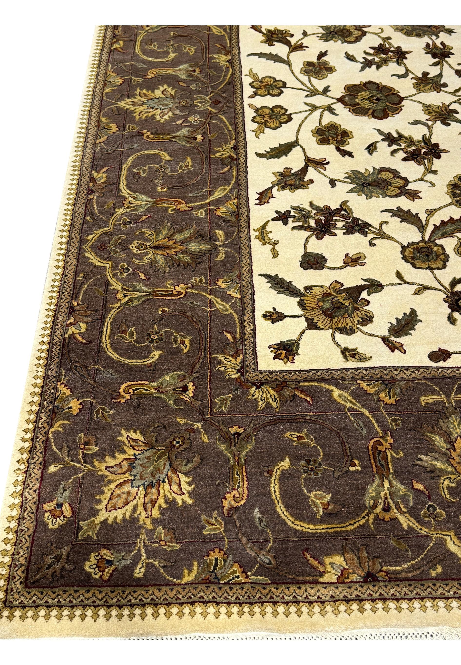 A close-up of the Indian Chobi rug's edge, highlighting the transition from the dark border to the floral central field with fine craftsmanship.
