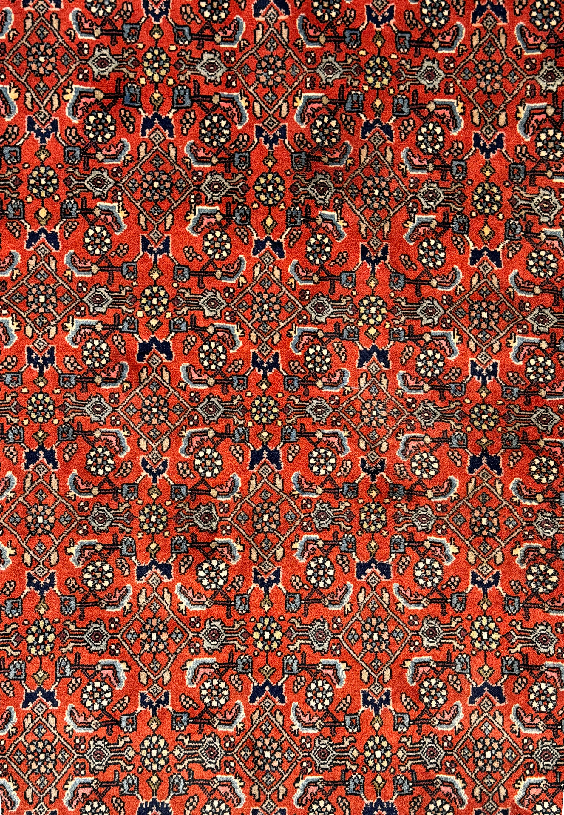 A close-up of the vintage Bijar rug's pattern, highlighting the detailed motifs and rich color palette.