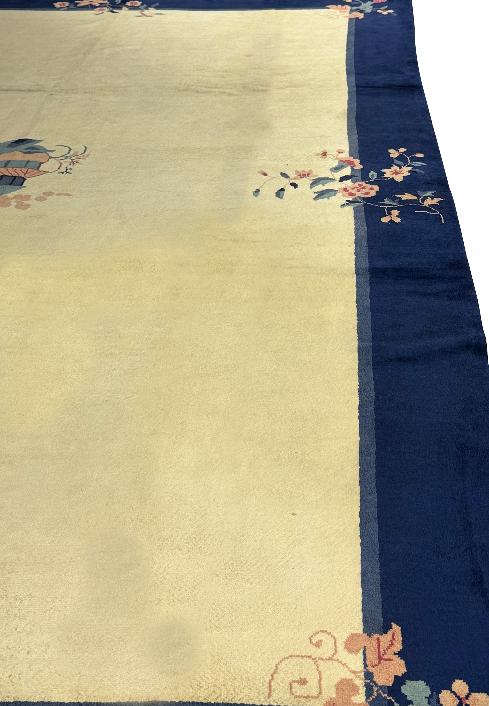 Close-up of the vintage Art Deco rug's weave, focusing on the seamless transition from the plush navy border to the beige center