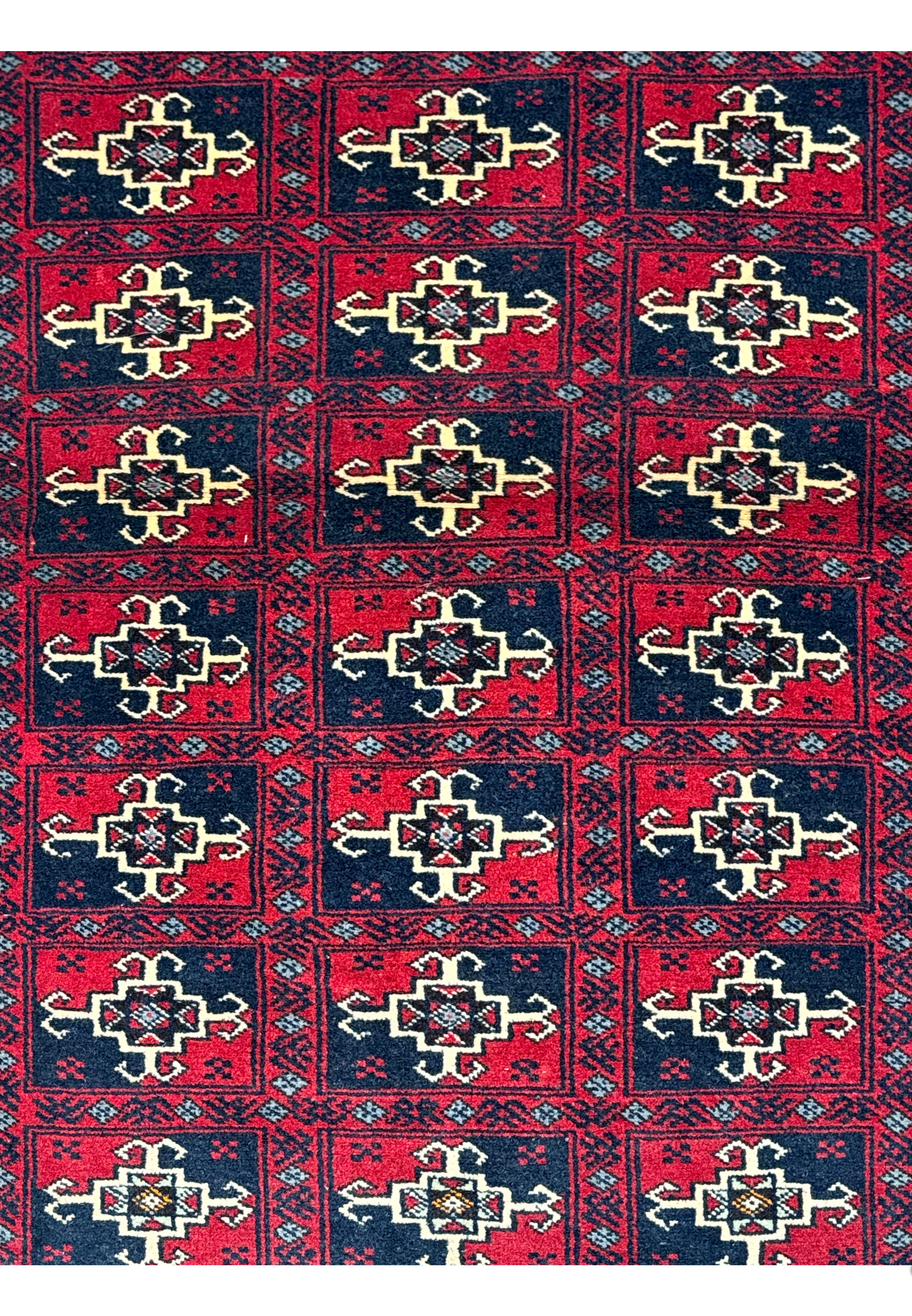 Close-up of the rug's patterns, displaying the detailed craftsmanship and the vibrant red and dark hues.