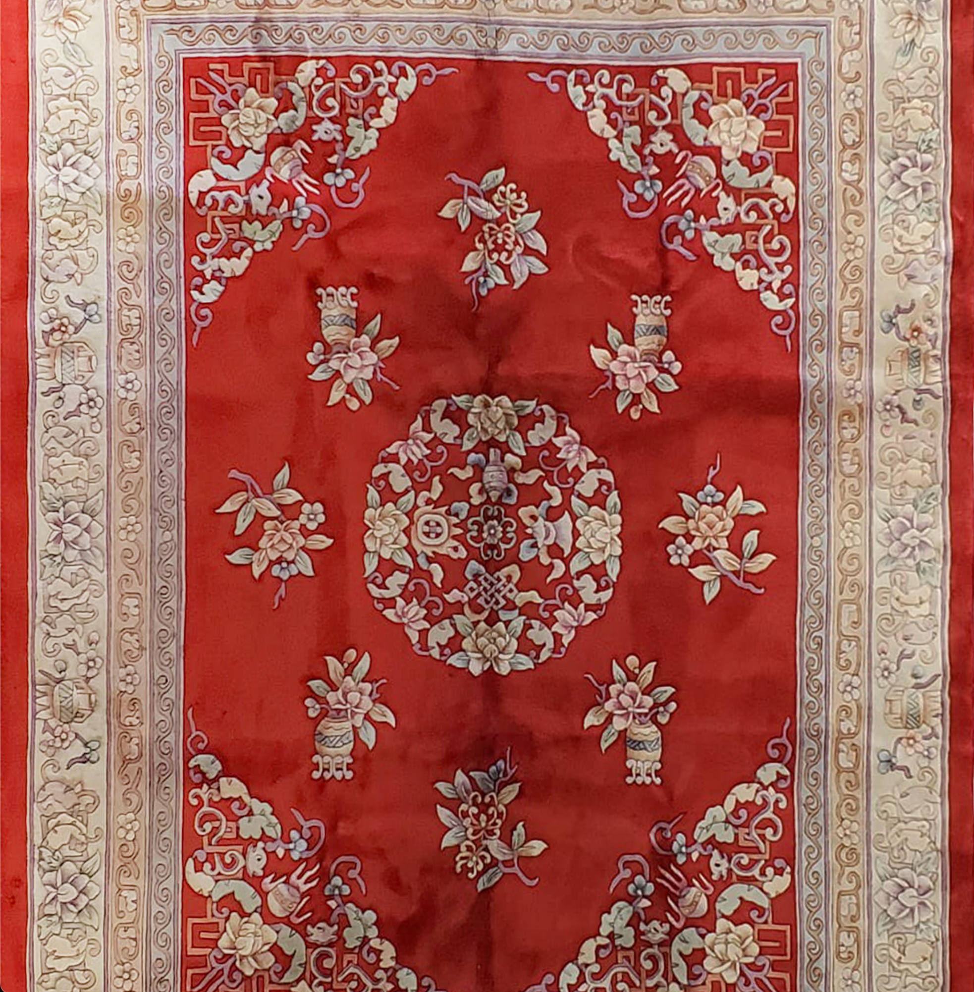 Zoomed-in section of a shiny red Chinese Art Deco wool rug, showing the variation in shades caused by its reflective wool and intricate floral patterns