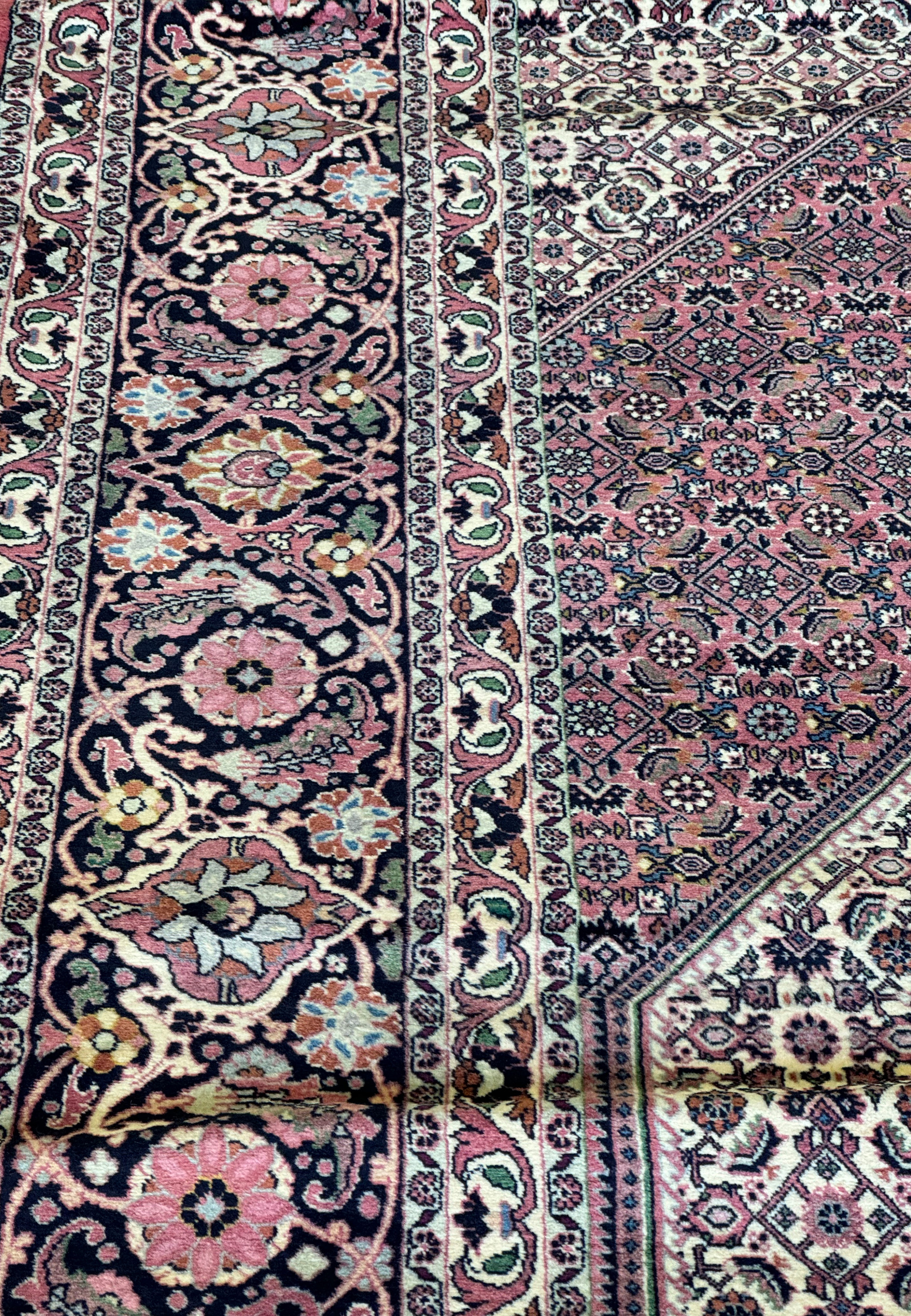 This Bijar Persian rug, measuring 12x17 feet, showcases a stunning medallion at its core, encircled by a symphony of symbolic elements and botanical patterns, all woven with precision and care