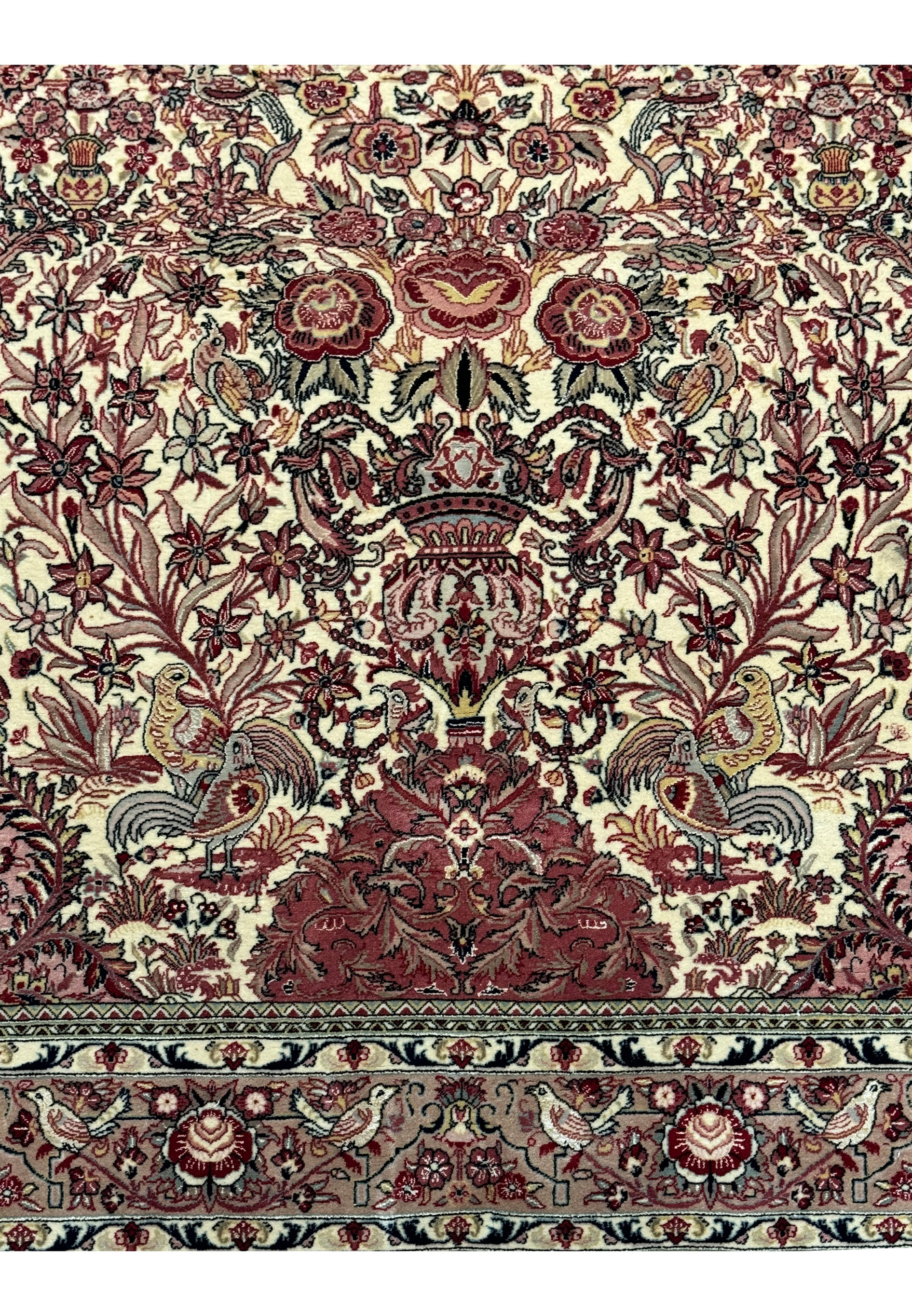 Close-up view showcasing the lower half of the Persian Qum rug, emphasizing the symmetry and rich colors of the floral designs and the fine craftsmanship of the weave.