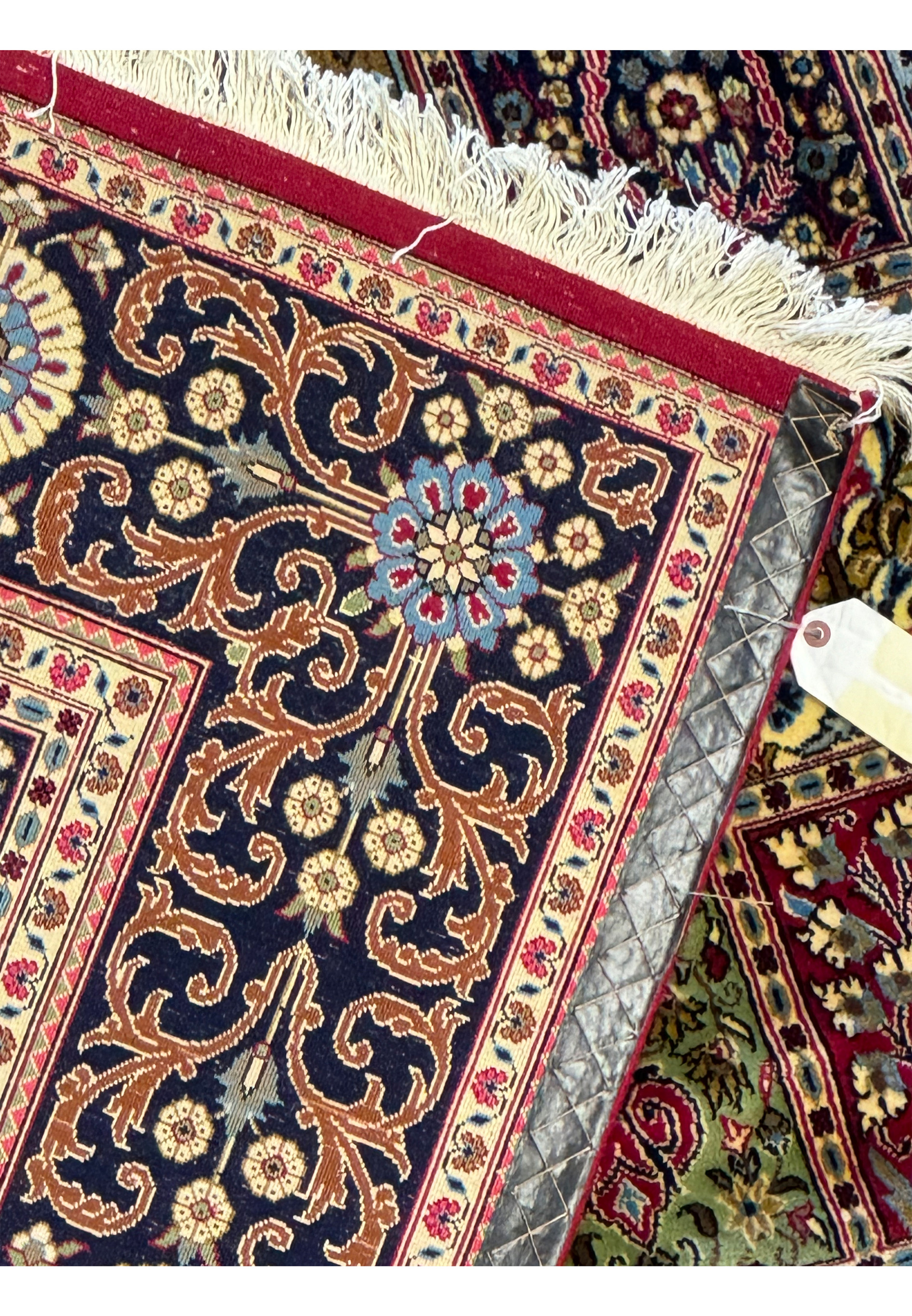 Reverse angle of a Persian Qum Kork rug displaying the underside weaving patterns, with a close-up on the detailed border craftsmanship.
