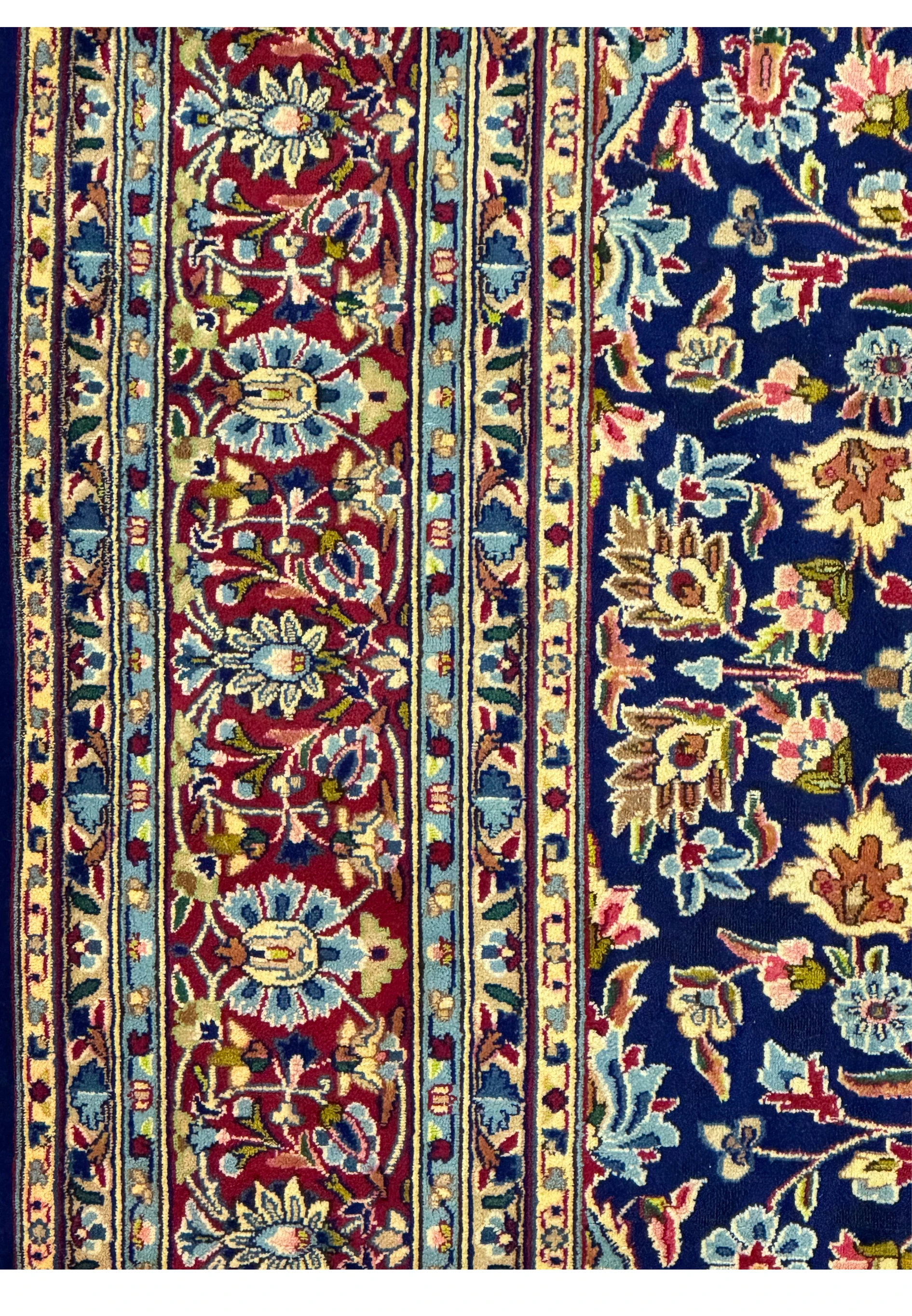 Detailed view of the lower right corner of a Persian Kerman Rug, showing the fine craftsmanship and the intricate design of the floral patterns.