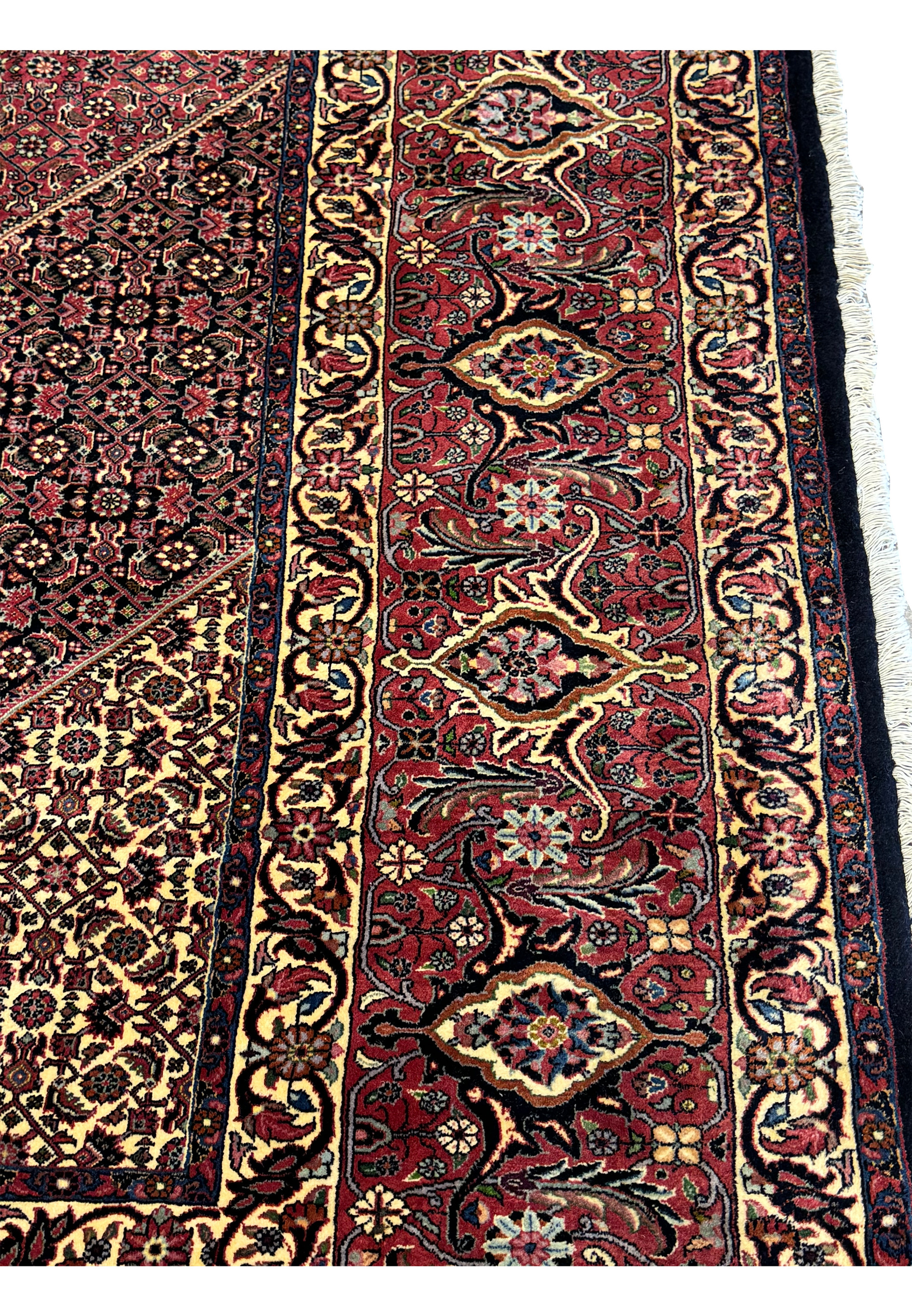 Close-up view of the intricate floral border design on the Persian Bijar Rug, showcasing the rich red and gold colors.