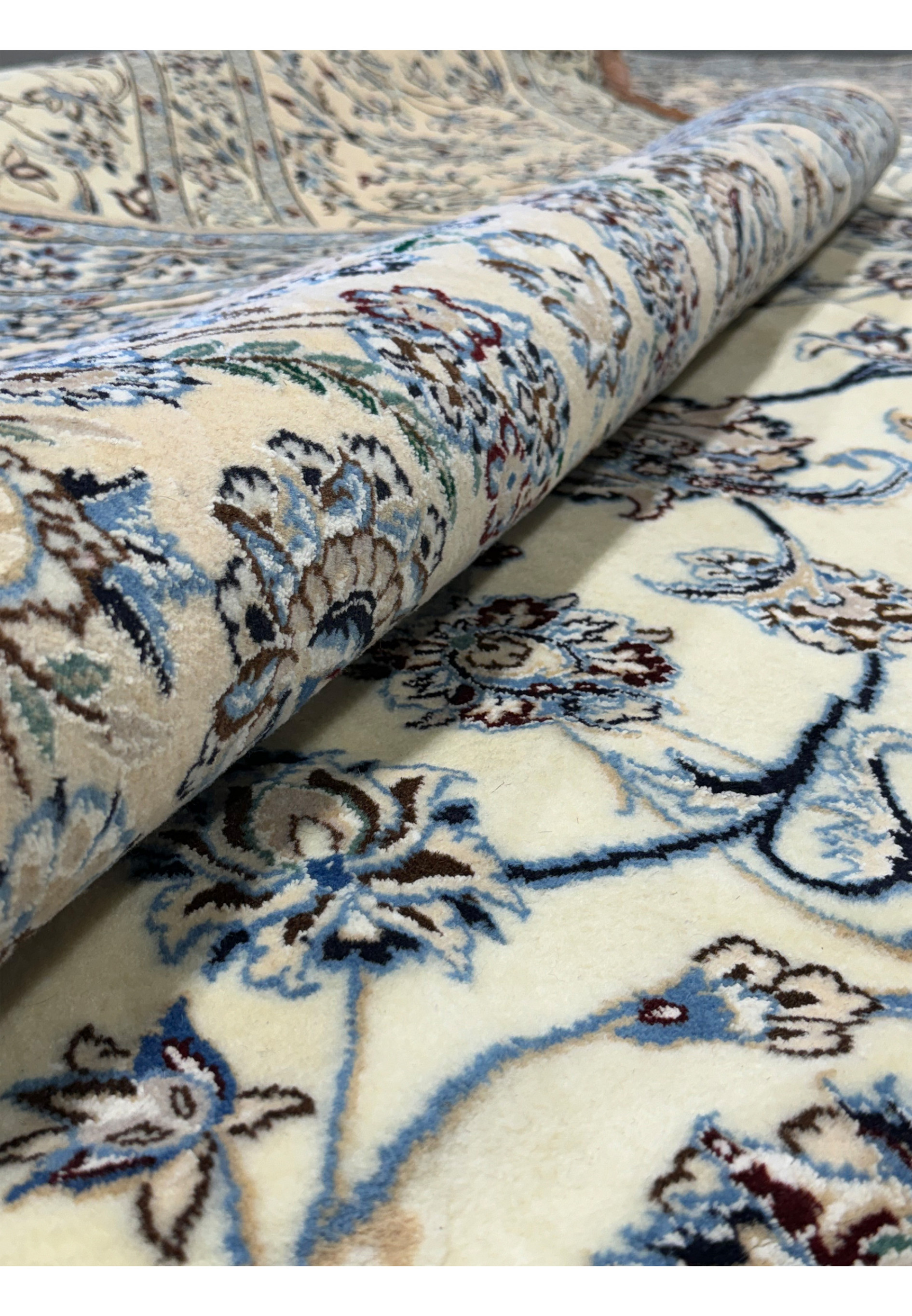 Close-up of the rolled edge of a Persian Nain 9LAA Wool & Silk Rug.