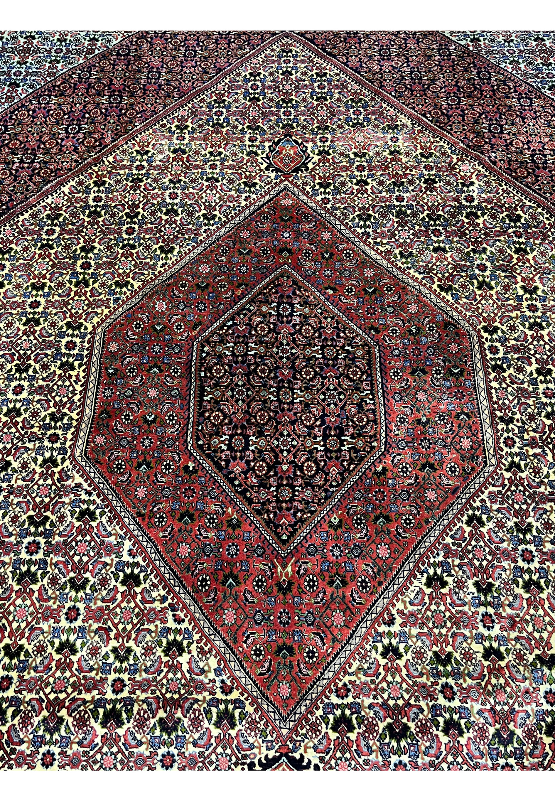 Central medallion view of a 9.8 x 12.2 Persian Bijar rug with layered geometric forms, dark red and navy tones, and a densely knotted symmetrical design.