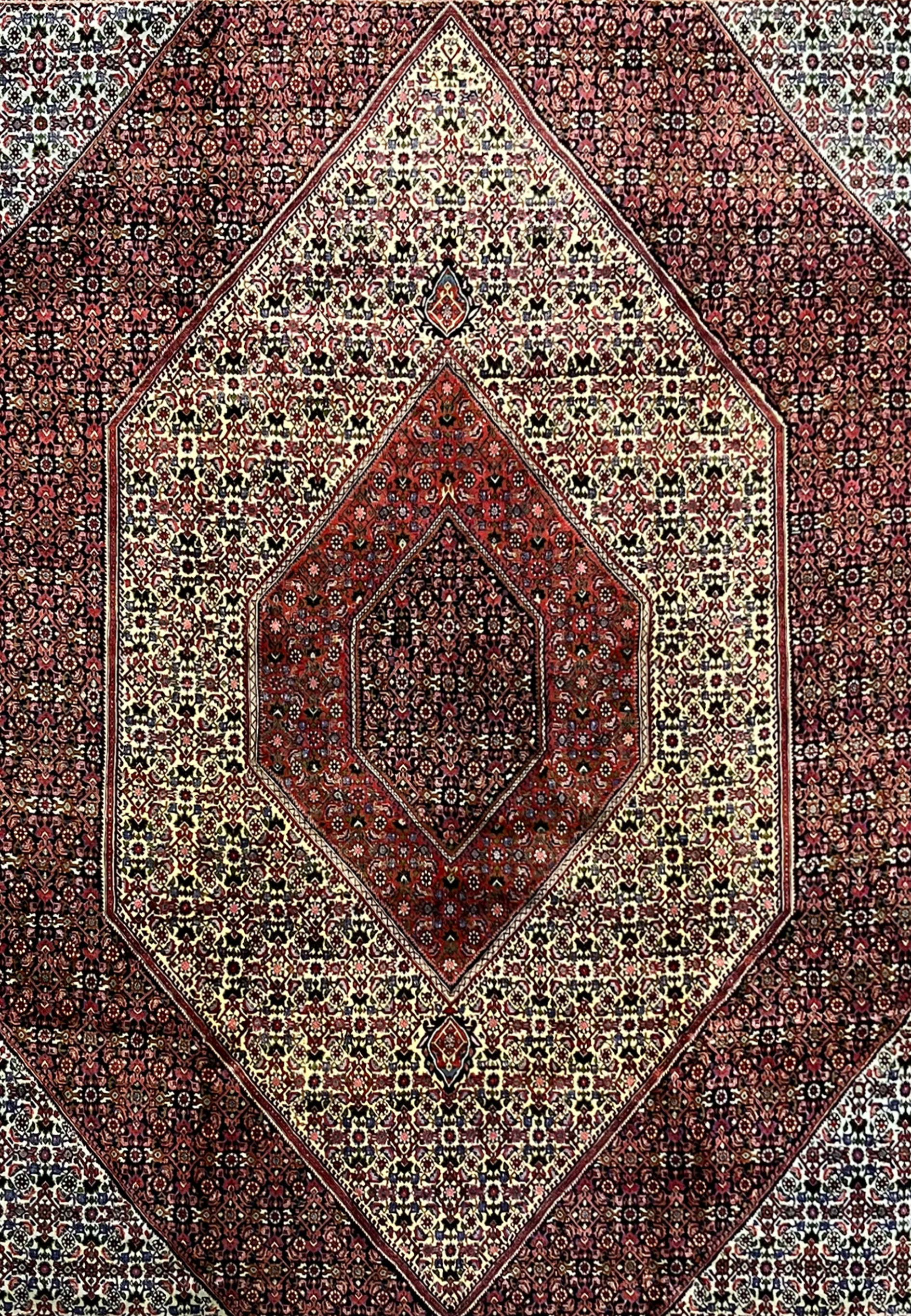 Midfield section of a 9.8 x 12.2 Persian Bijar rug highlighting intricate repeating patterns, ivory ground, and deep red and navy geometric ornamentation.