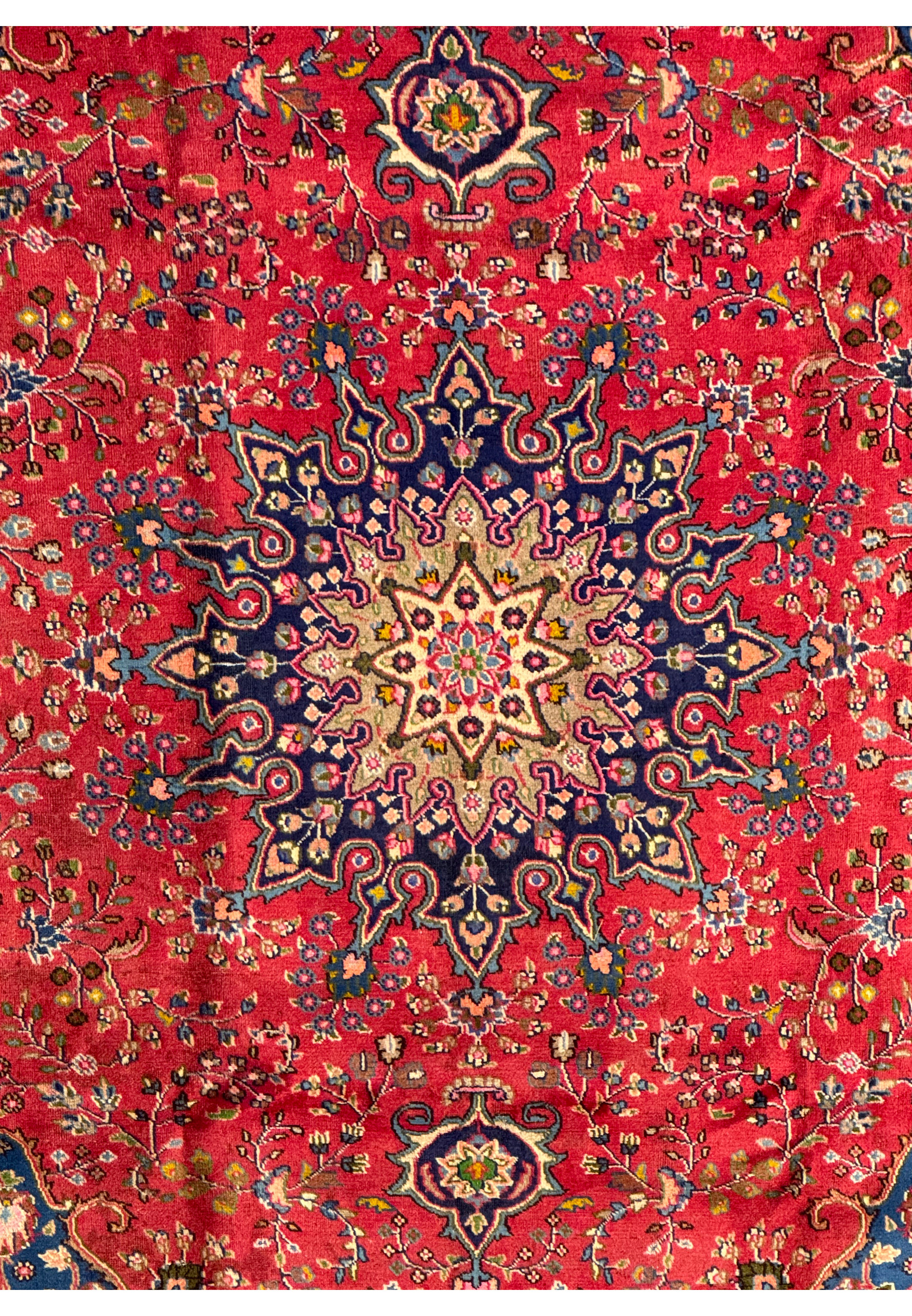 Detailed shot of the corner of the Persian Mashad rug, displaying the rich colors and intricate designs.