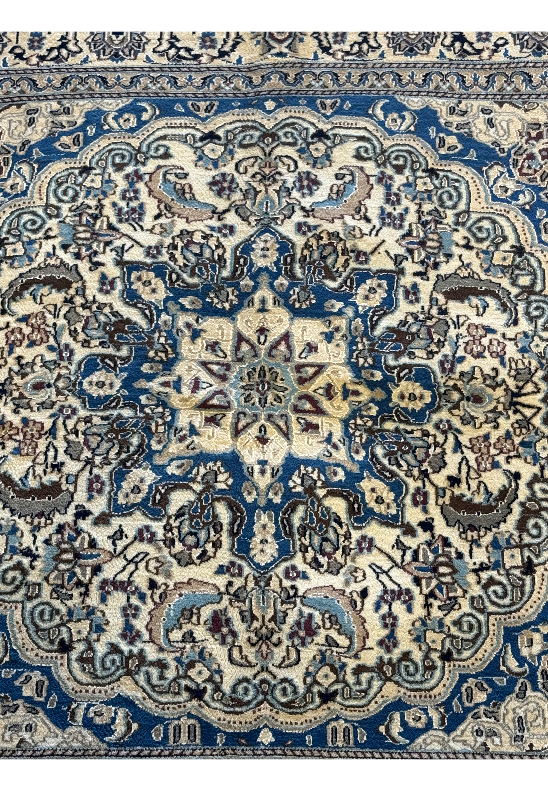 Close-up of the central medallion on the Persian Nain Square Rug, highlighting the detailed floral motifs.