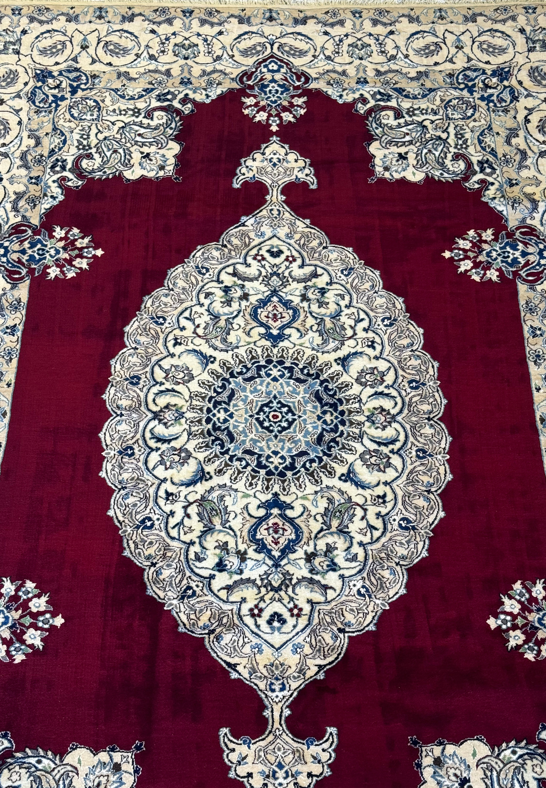 Midfield view of the 6'8 x 10'4 Persian Nain 9LAA Wool & Silk Rug, highlighting the detailed floral and vine patterns.