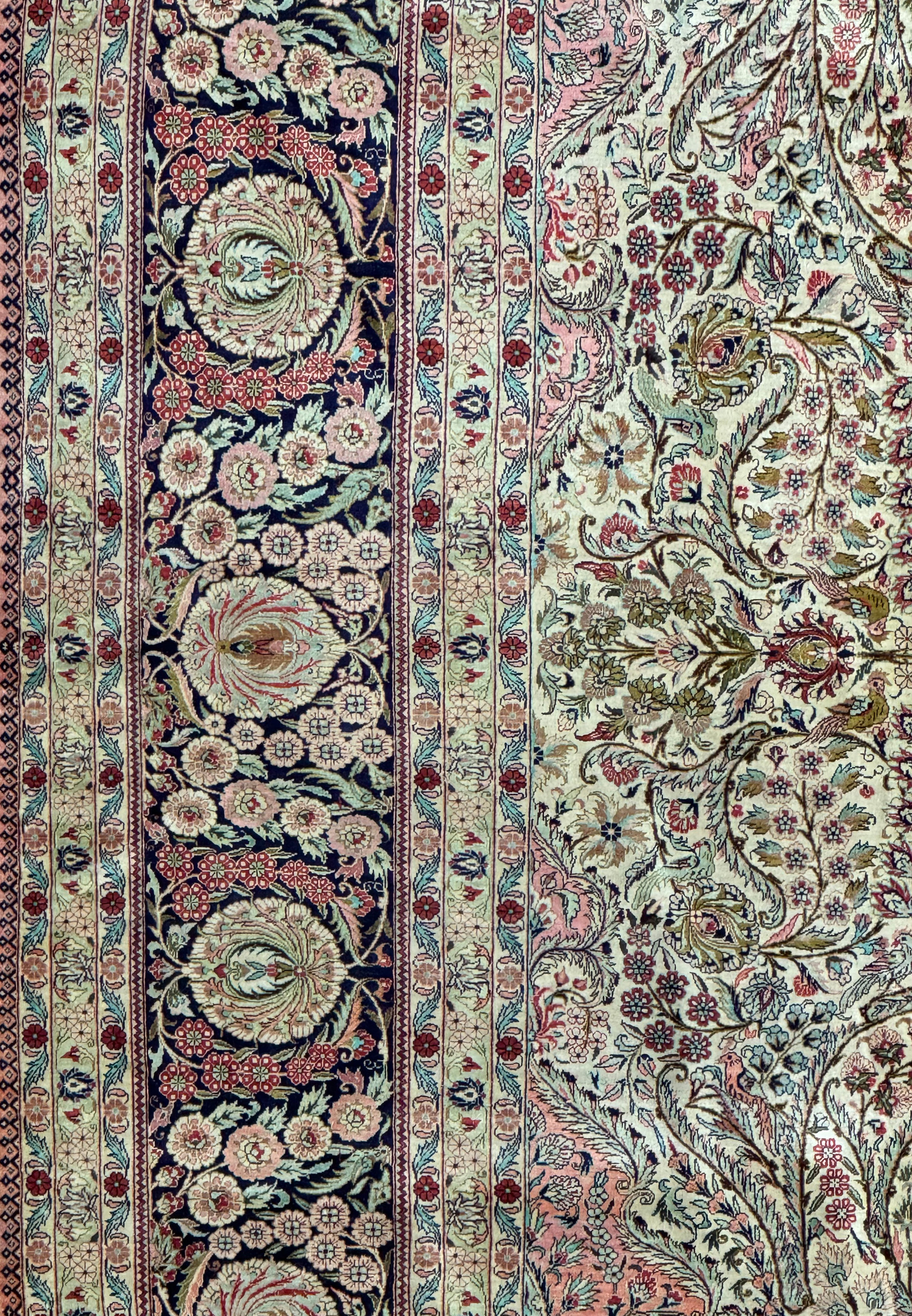 Corner detail of a Persian Tabriz 100% silk rug showcasing floral border design