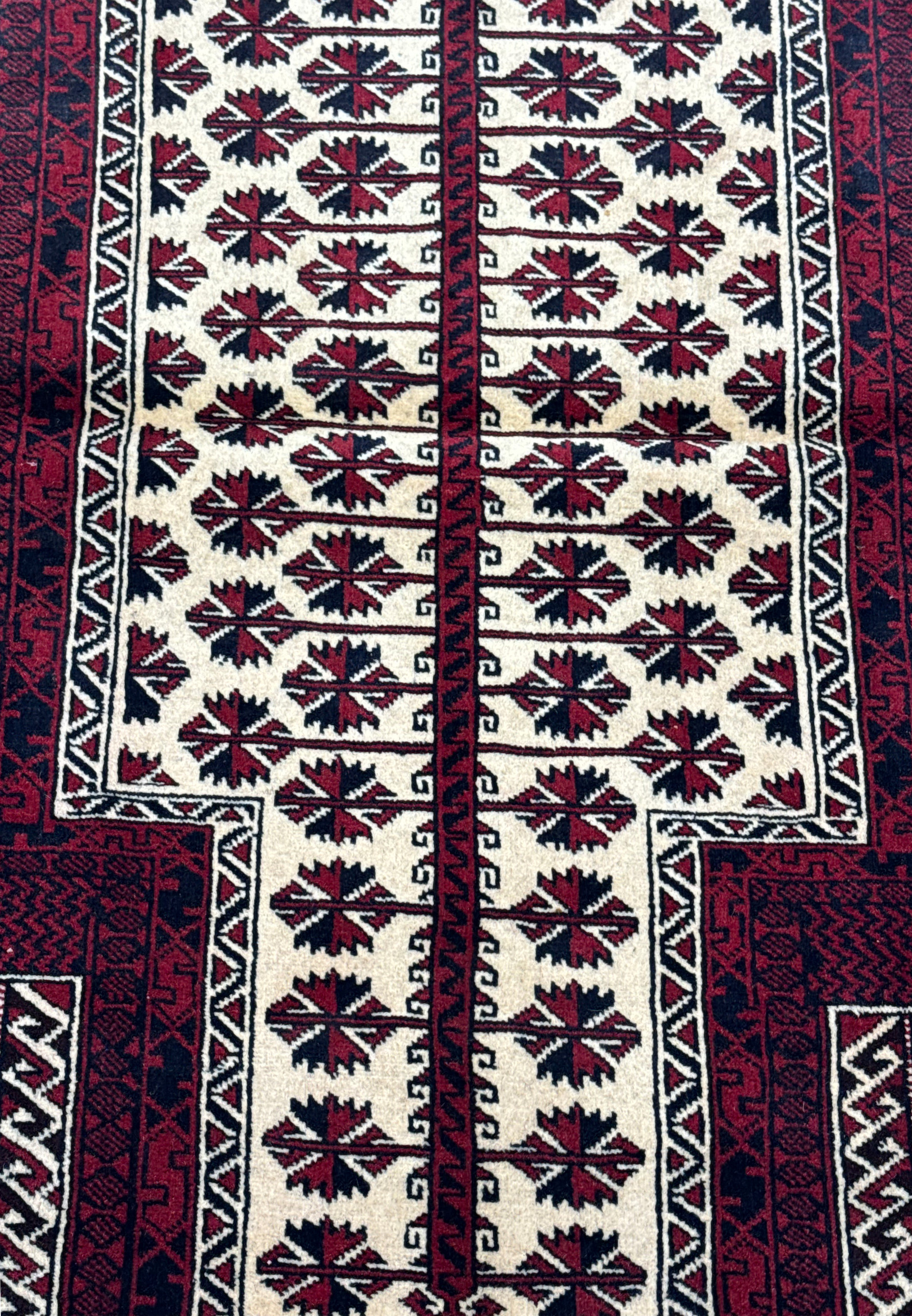 Close-up of the central geometric and star patterns on a 3'1 x 4'2 Persian Baluch rug, highlighting the intricate weaving and vibrant colors.