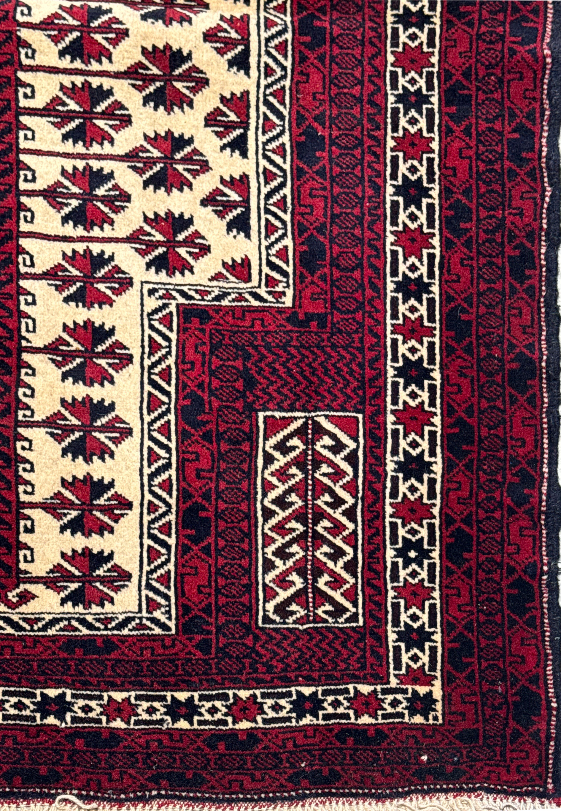 Side view of a 3'1 x 4'2 Persian Baluch rug showing the rich, dense wool pile and intricate geometric patterns with fringed edges.
