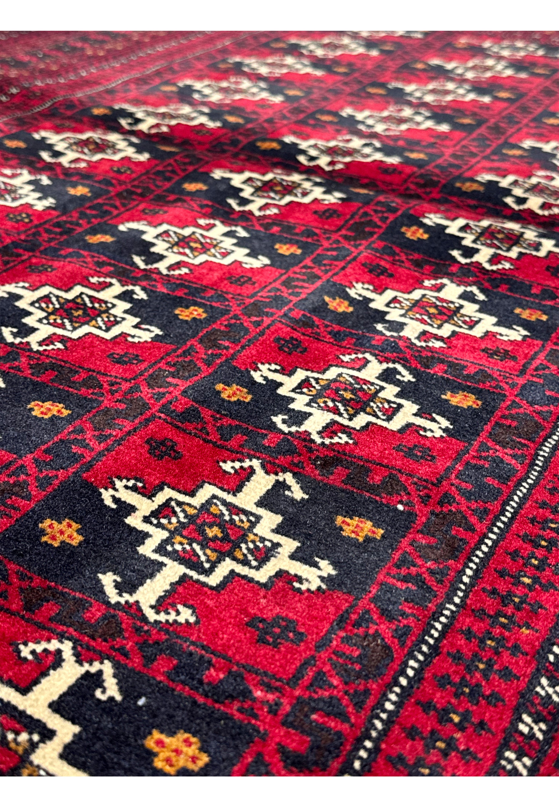 Perspective view of 3'6 x 4'9 Persian Baluch Rug displaying texture and design.