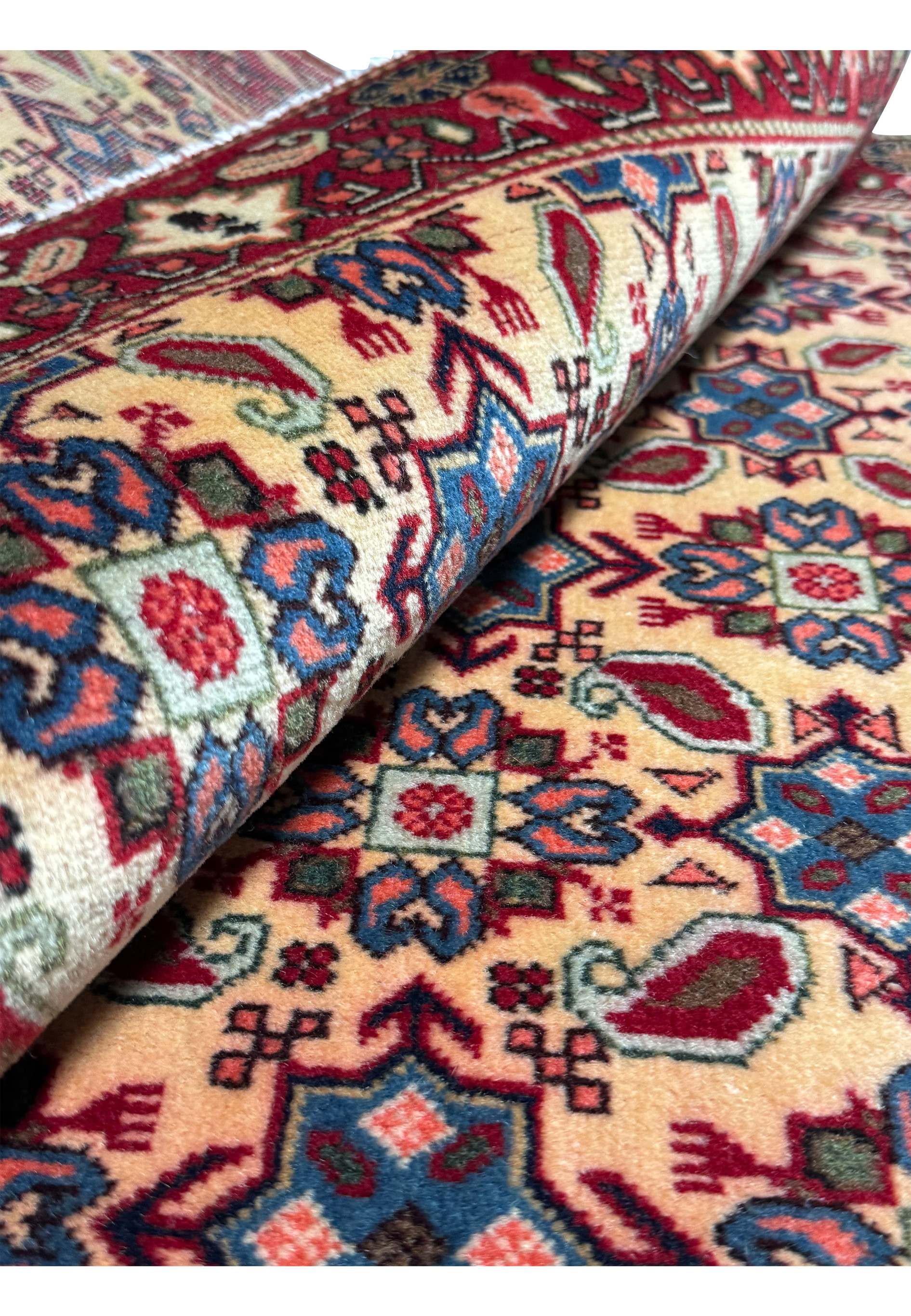 Side view of a rolled 3'4 x 5'3 Persian Hamedan Rug, displaying the texture and intricate weaving.