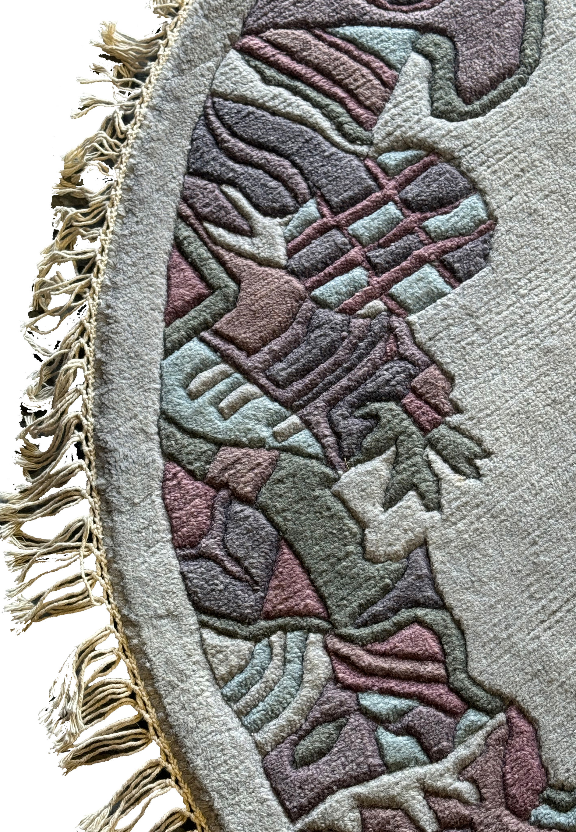 Detailed view of the border of the round Nepal rug, highlighting the layered, geometric design in shades of purple, green, and gray.