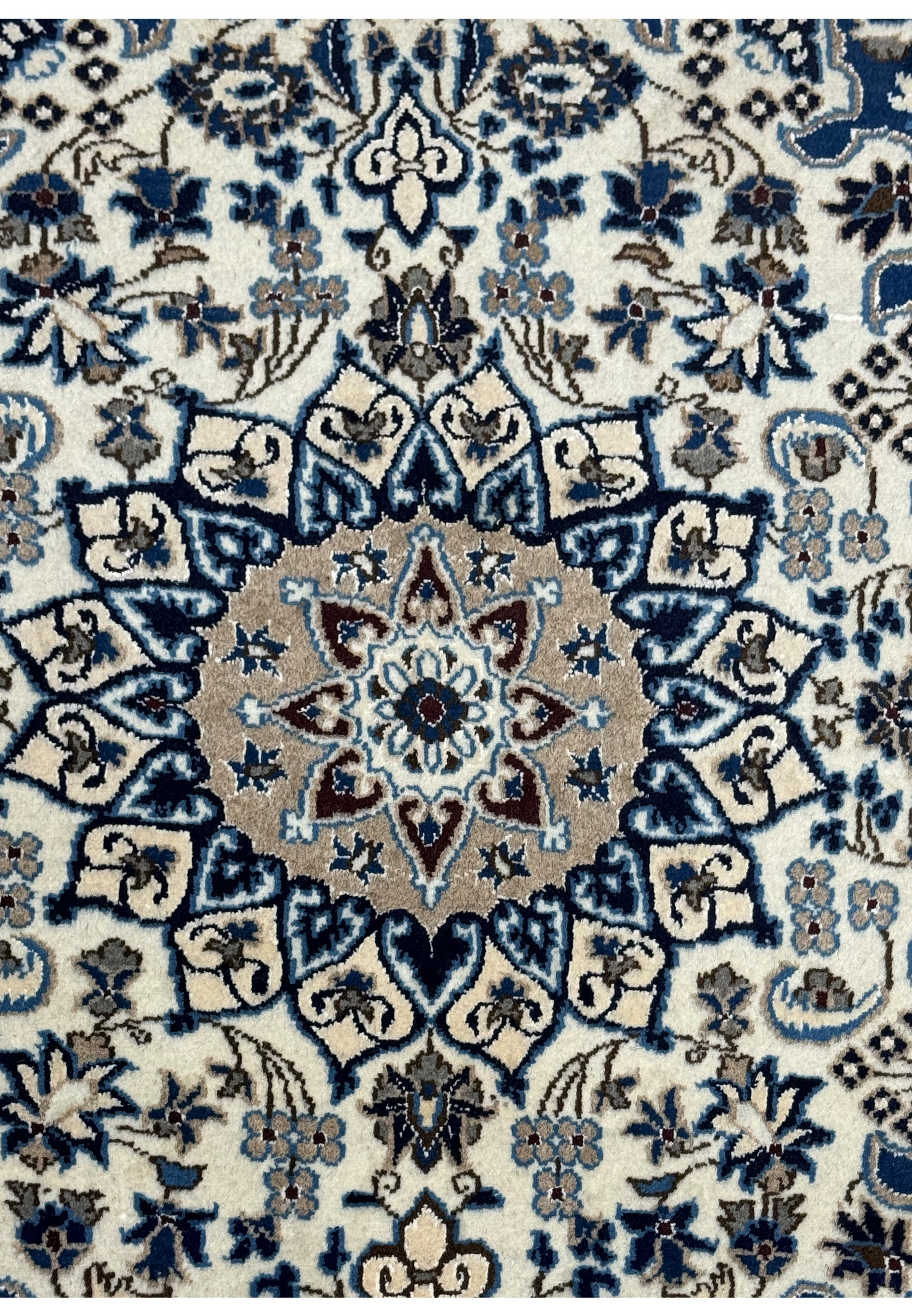 Close-up of the medallion design on the 2'11 x 4'5 Persian Nain rug showcasing intricate patterns and color contrasts.