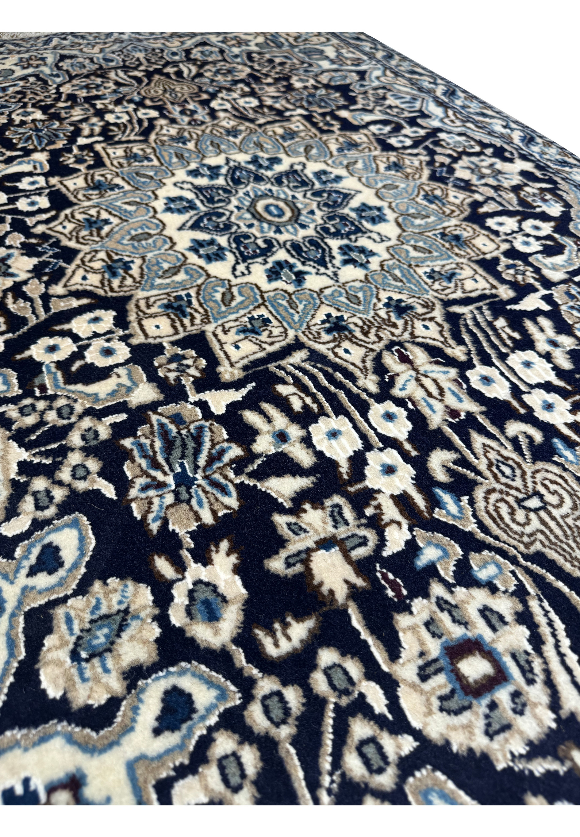 Side view of a 3x5 Nain Persian rug displaying its thickness and weave texture.