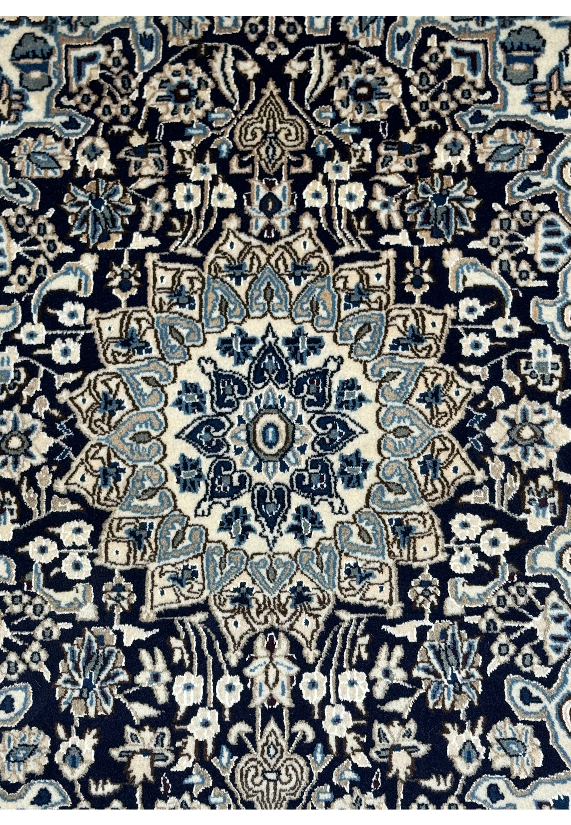 Close-up of the central medallion on a 3x5 Nain Persian rug with detailed patterns.