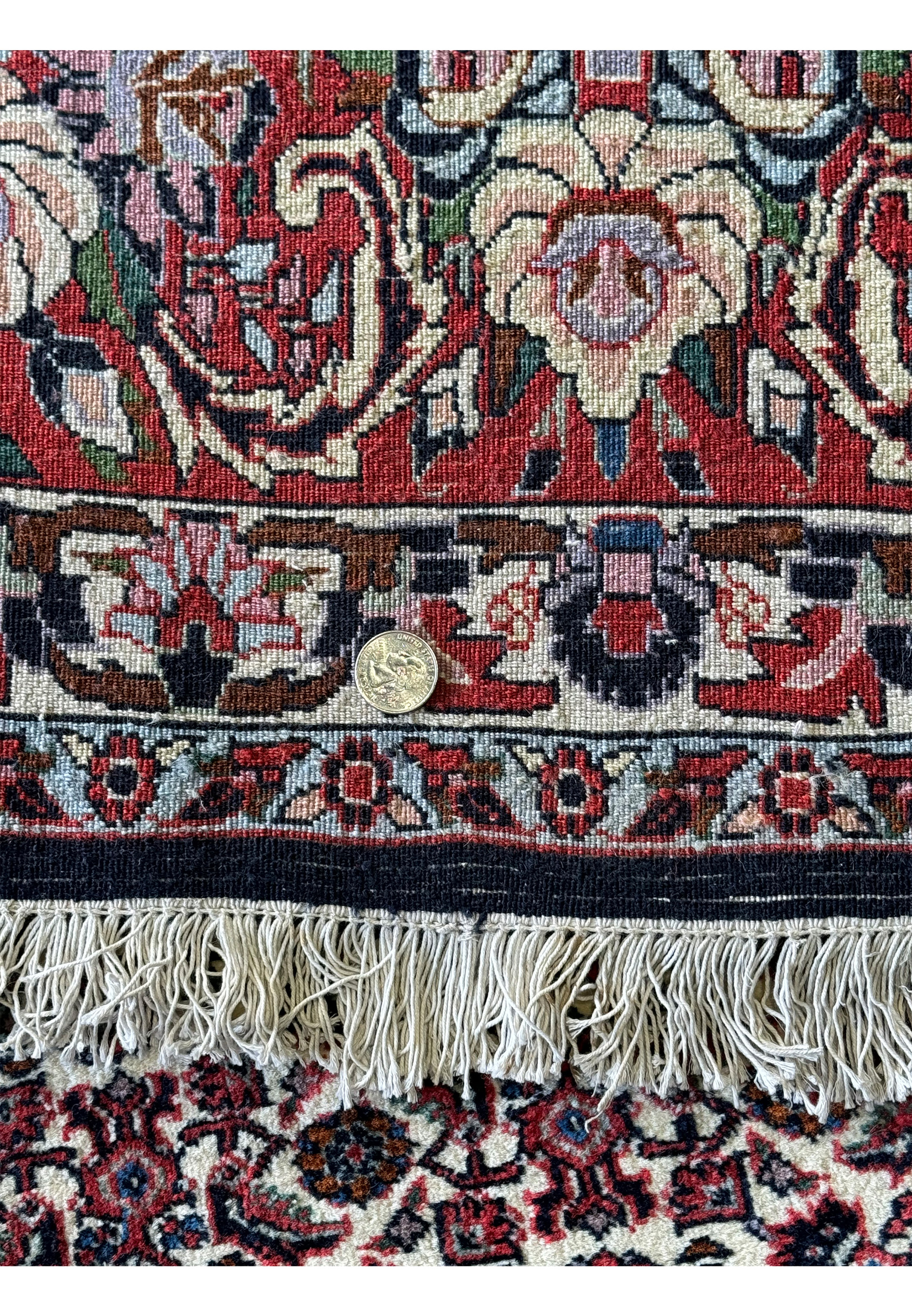 Detailed view of the dense weave on the back of a 9'10" x 13'1" Persian Bijar Rug, with a coin for scale comparison.