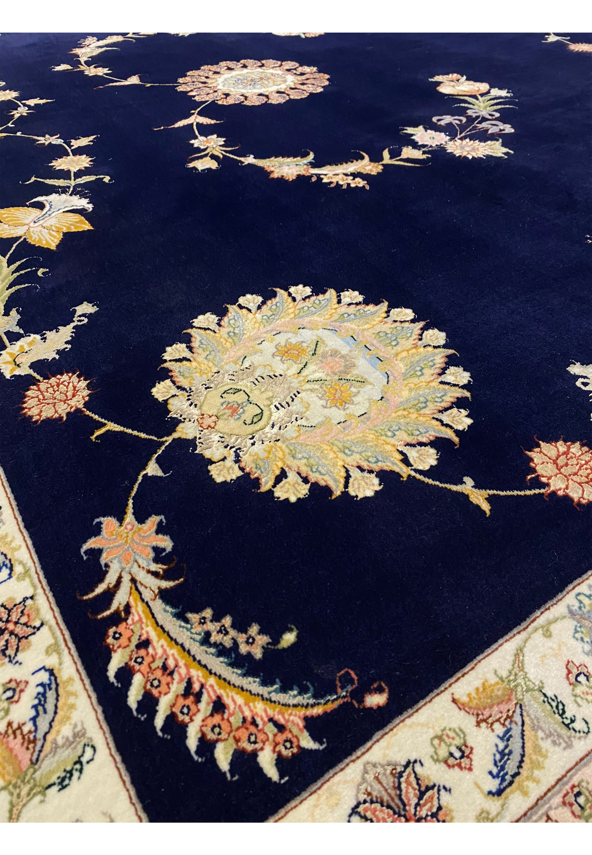 Elaborate floral patterns woven in silk on the 10x13 Persian Tabriz rug