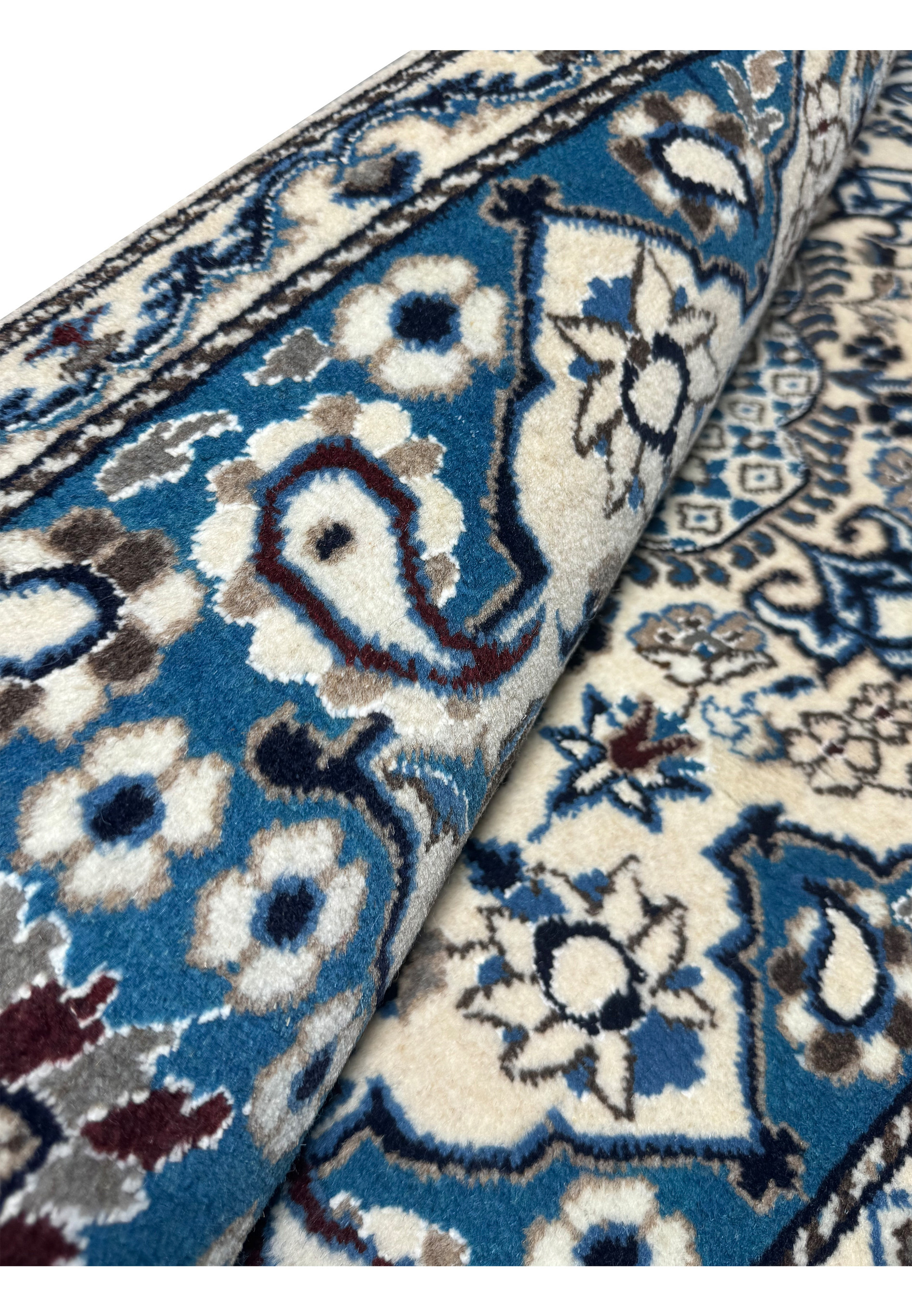 2'9 x 4'7 Persian Nain Rug rolled up to display the dense wool pile.