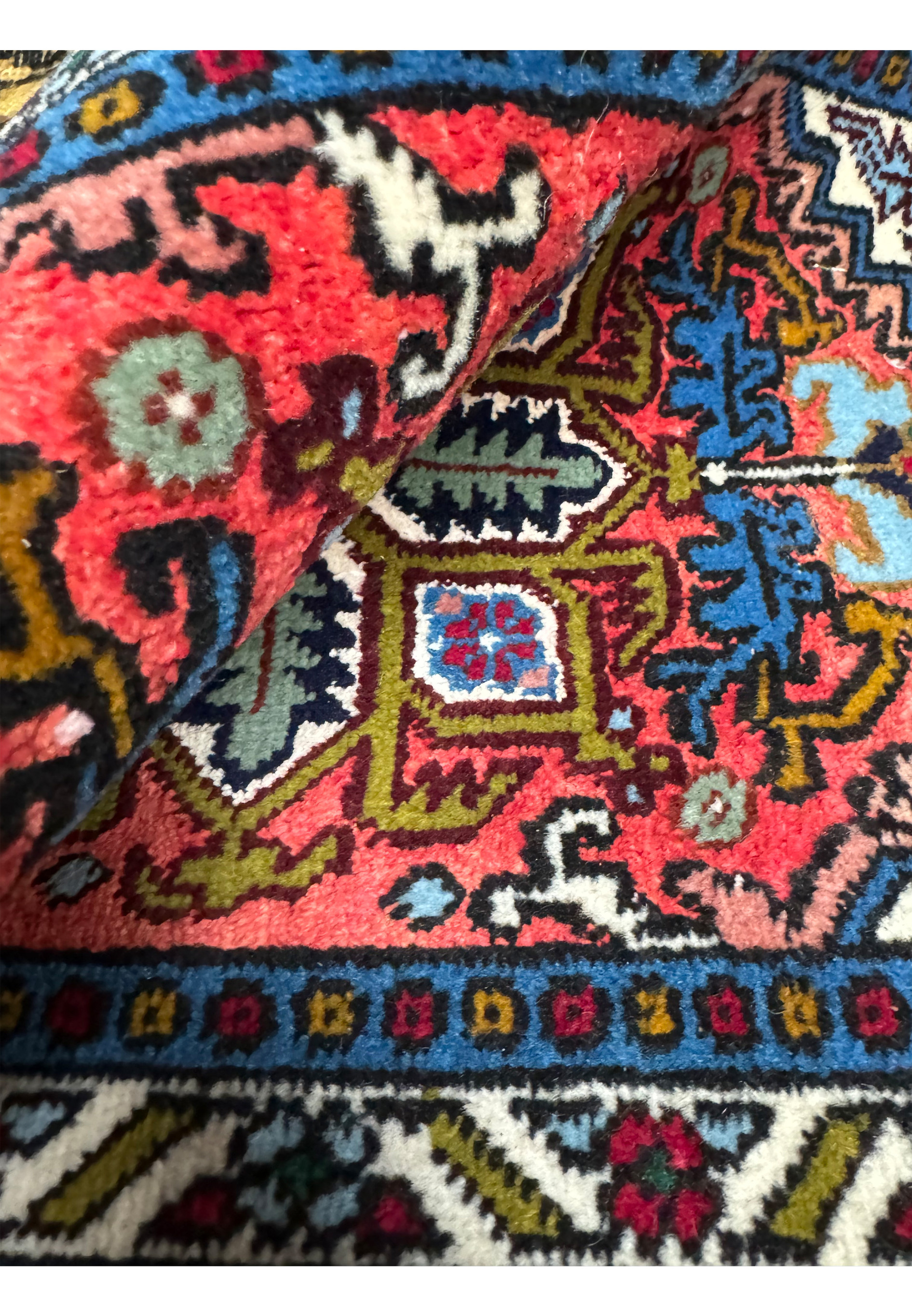 The rolled Persian Ardebil Wool and Silk Poshti Rug displaying the plush texture.