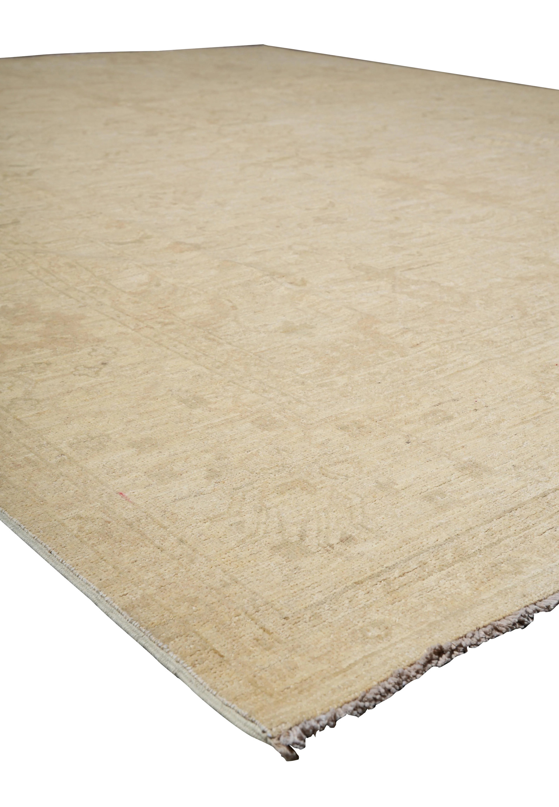 Angled view from corner of Chobi rug showing layout, border framing, and muted neutral pattern in context.