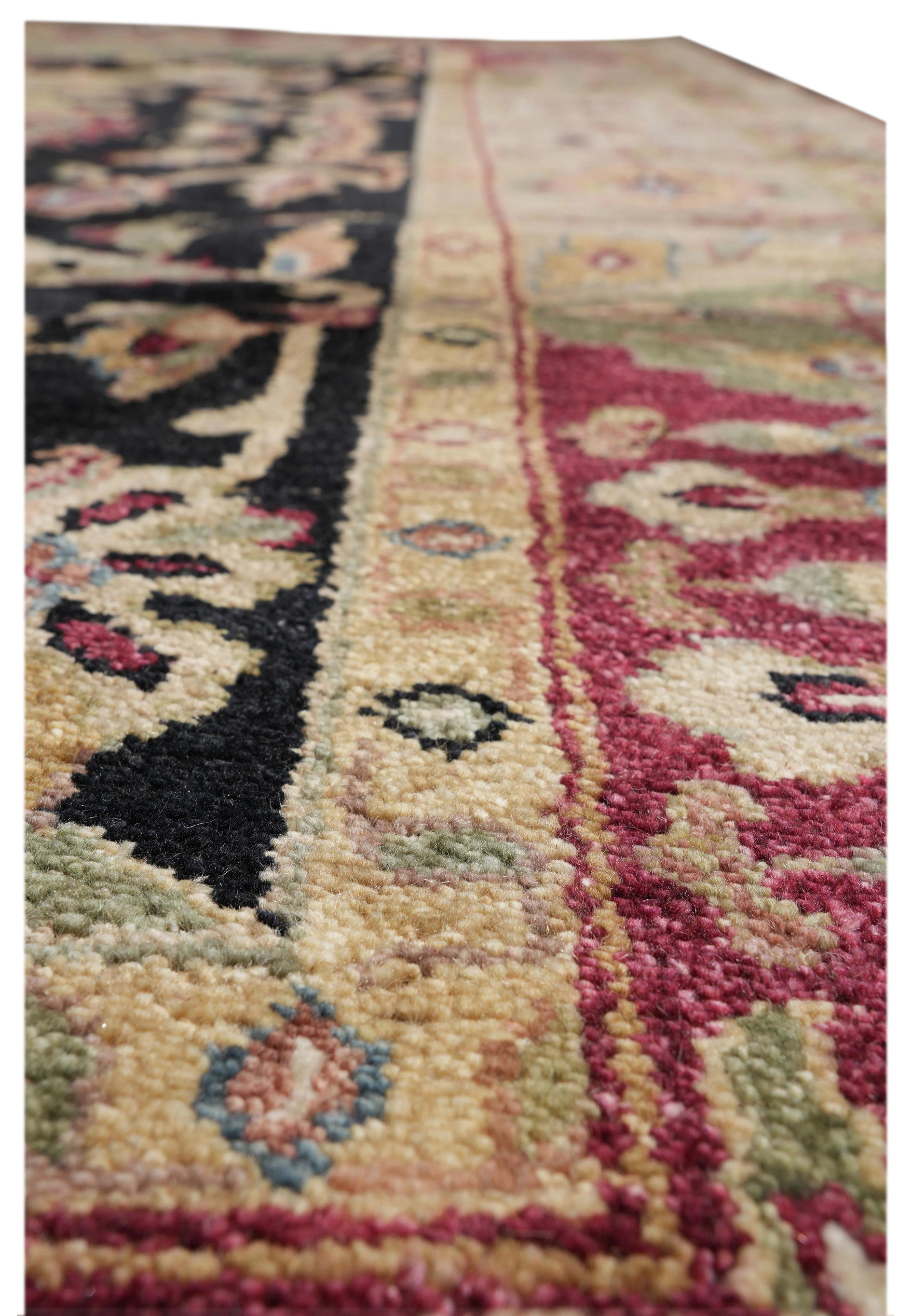 Close-up of Oushak rug texture featuring floral medallion in burgundy, black, gold, and olive with visible wool pile.