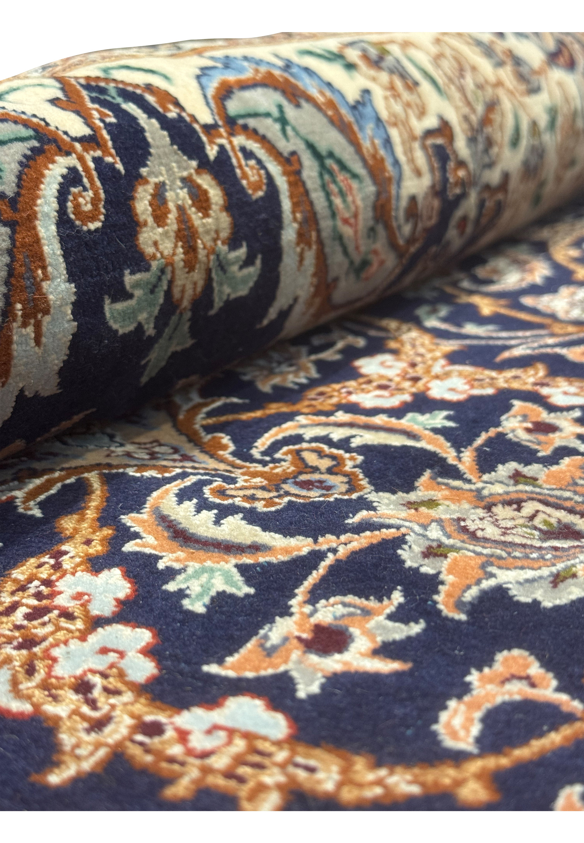 Side angle of Persian Isfahan rug partially rolled, highlighting texture and fine silk and wool weave