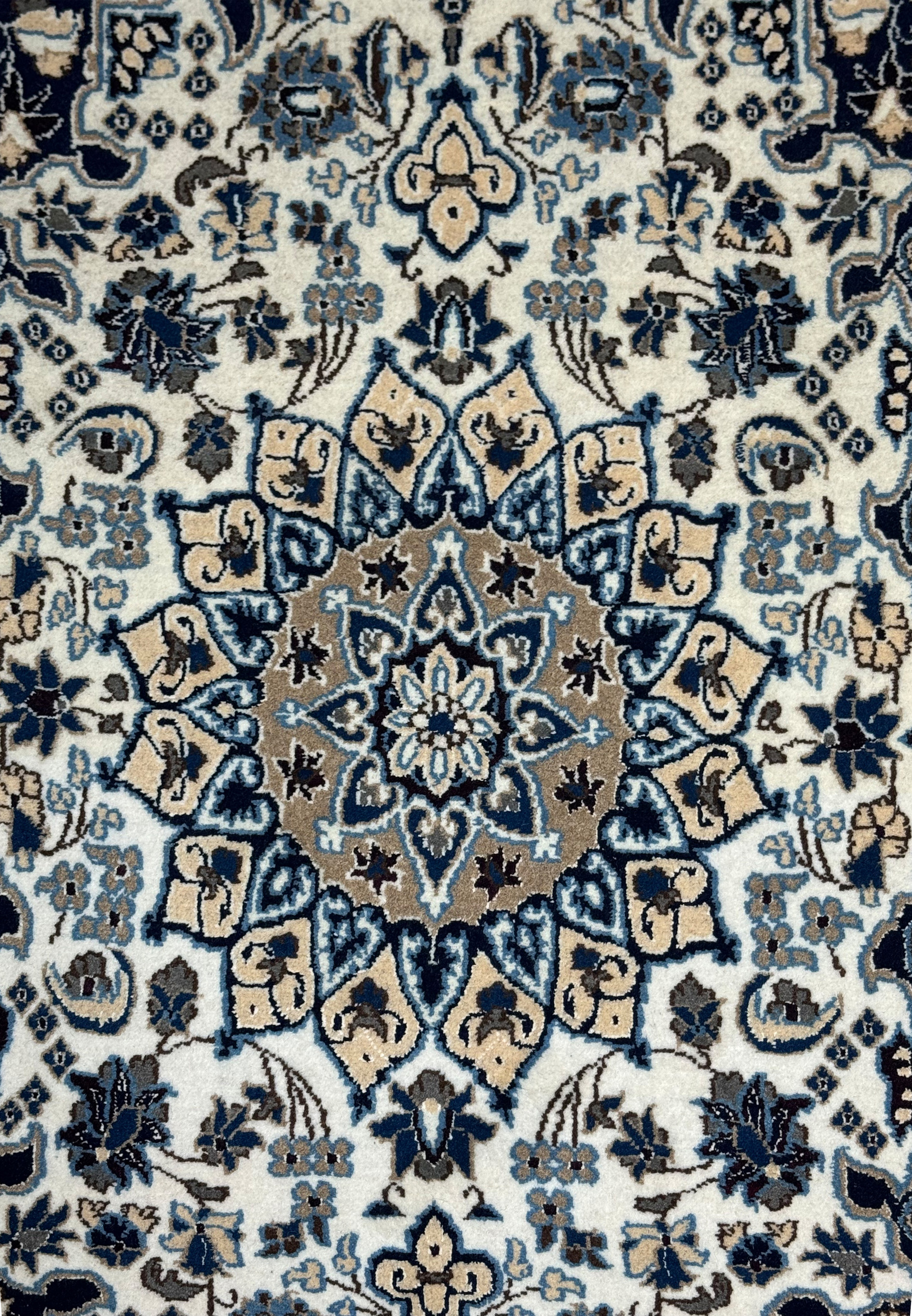 Medallion close-up of 2'9 x 4'10" Ivory Nain Persian Rug with beige, blue, and navy petals
