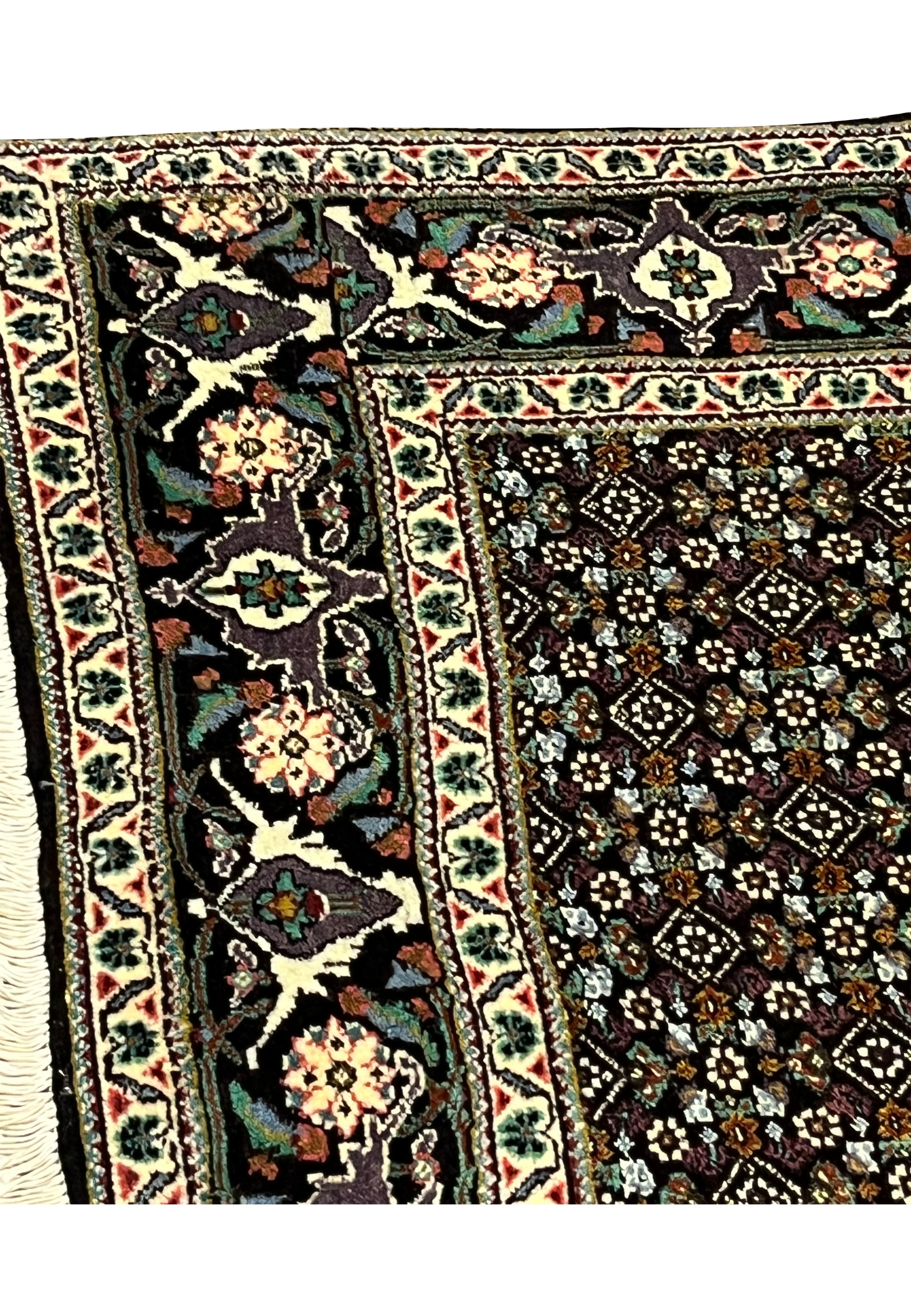 Upper floral border with palmettes and vines on Tabriz Mahi rug
