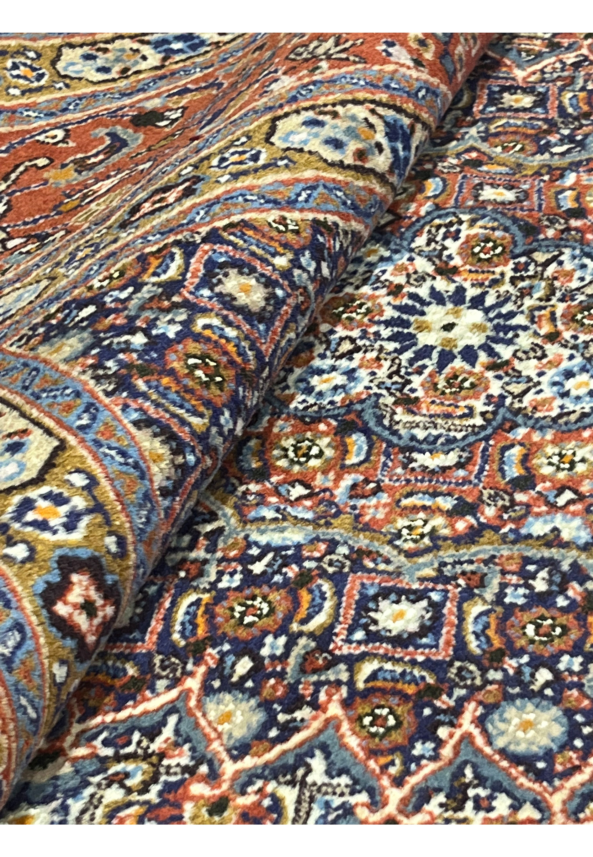 Rolled view of the Persian Moud rug revealing pile thickness, intricate weaving, and vivid color interplay between the ivory base, red borders, and navy medallion details.